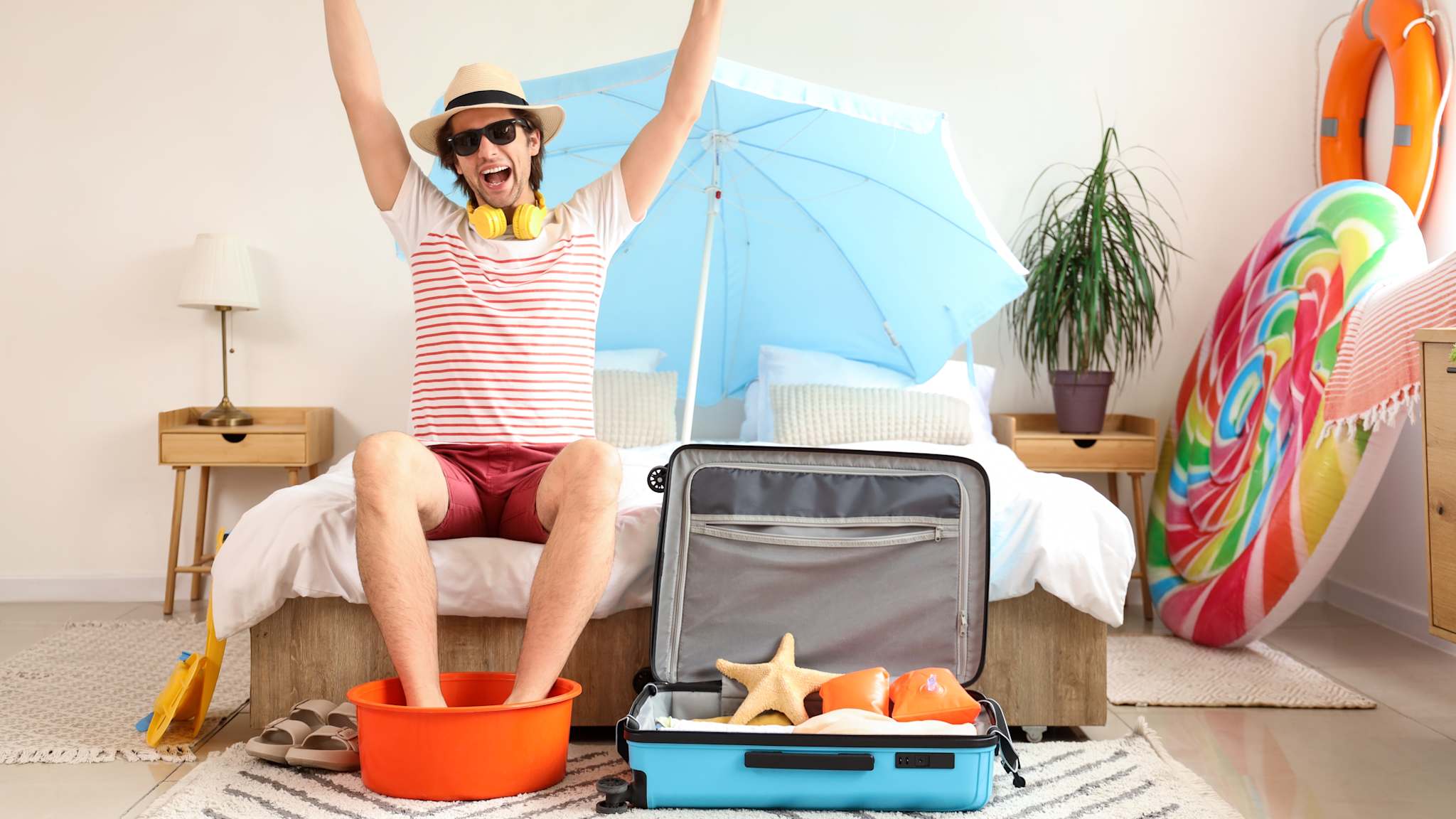 Glücklicher Urlauber mit Koffer im Schlafzimmer © shutterstock_2465436107