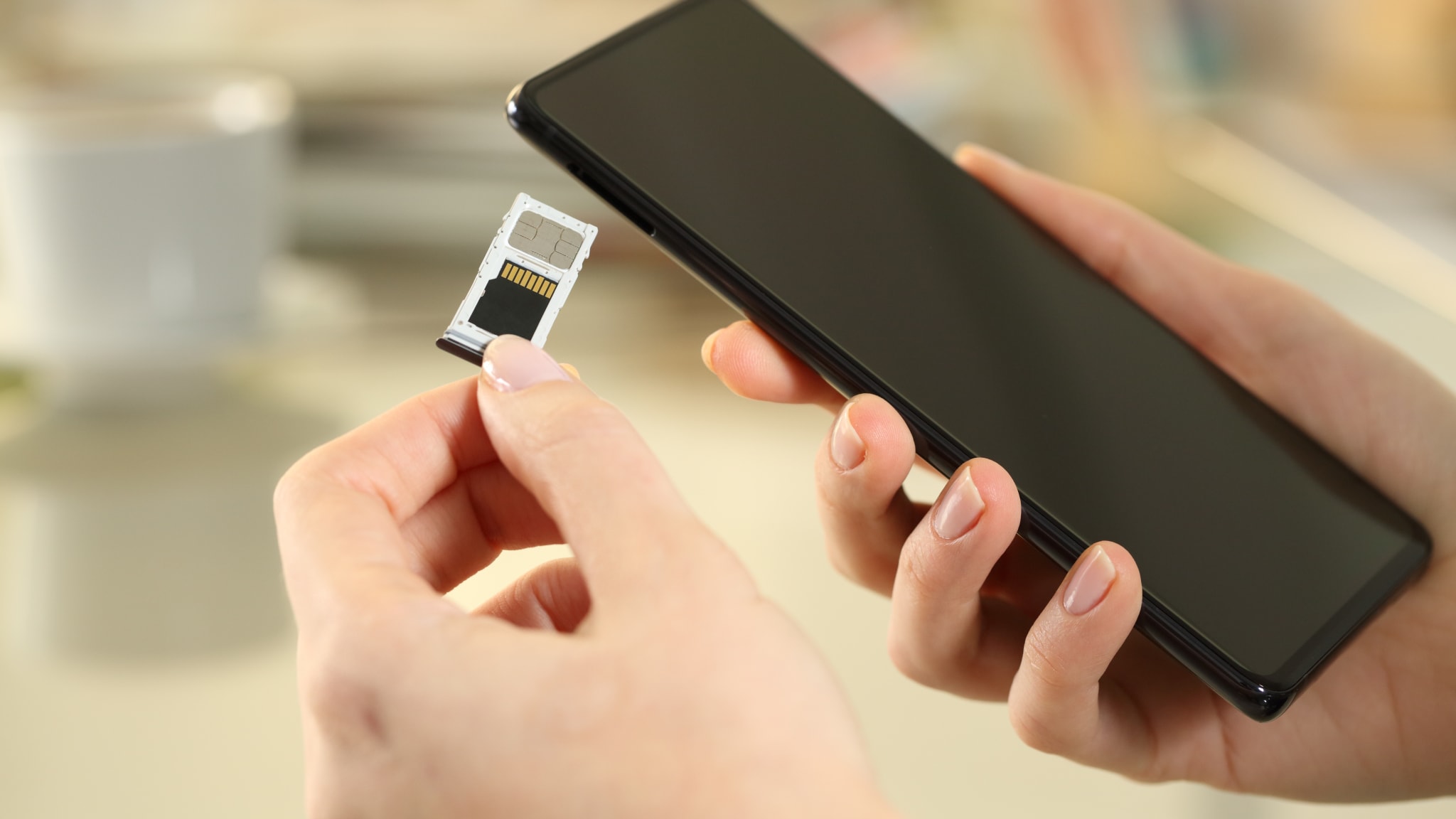 Eine Frau setzt eine SD-Karte in ein Smartphone ein