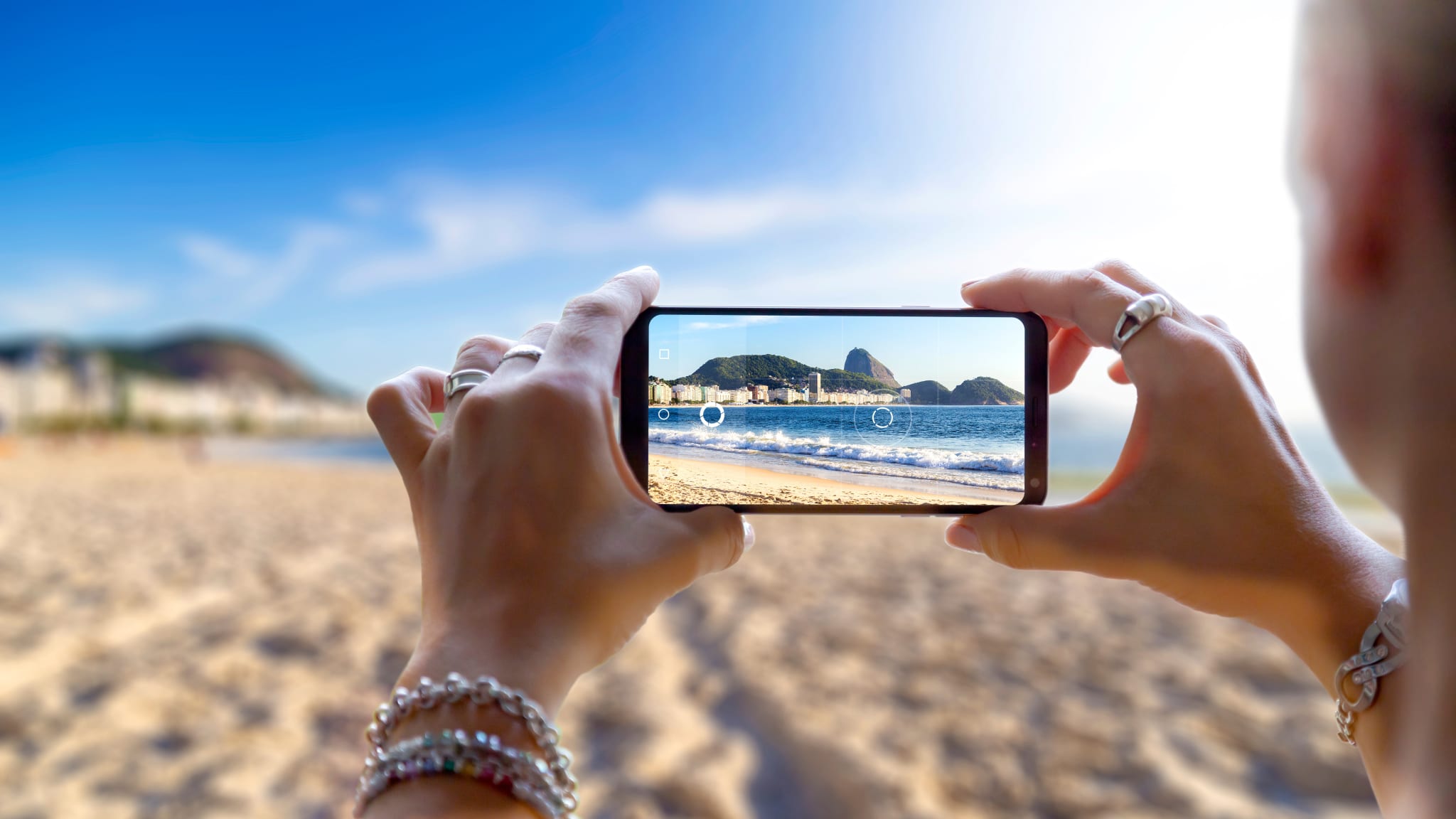 Blick auf einen Strand durch ein Smartphone