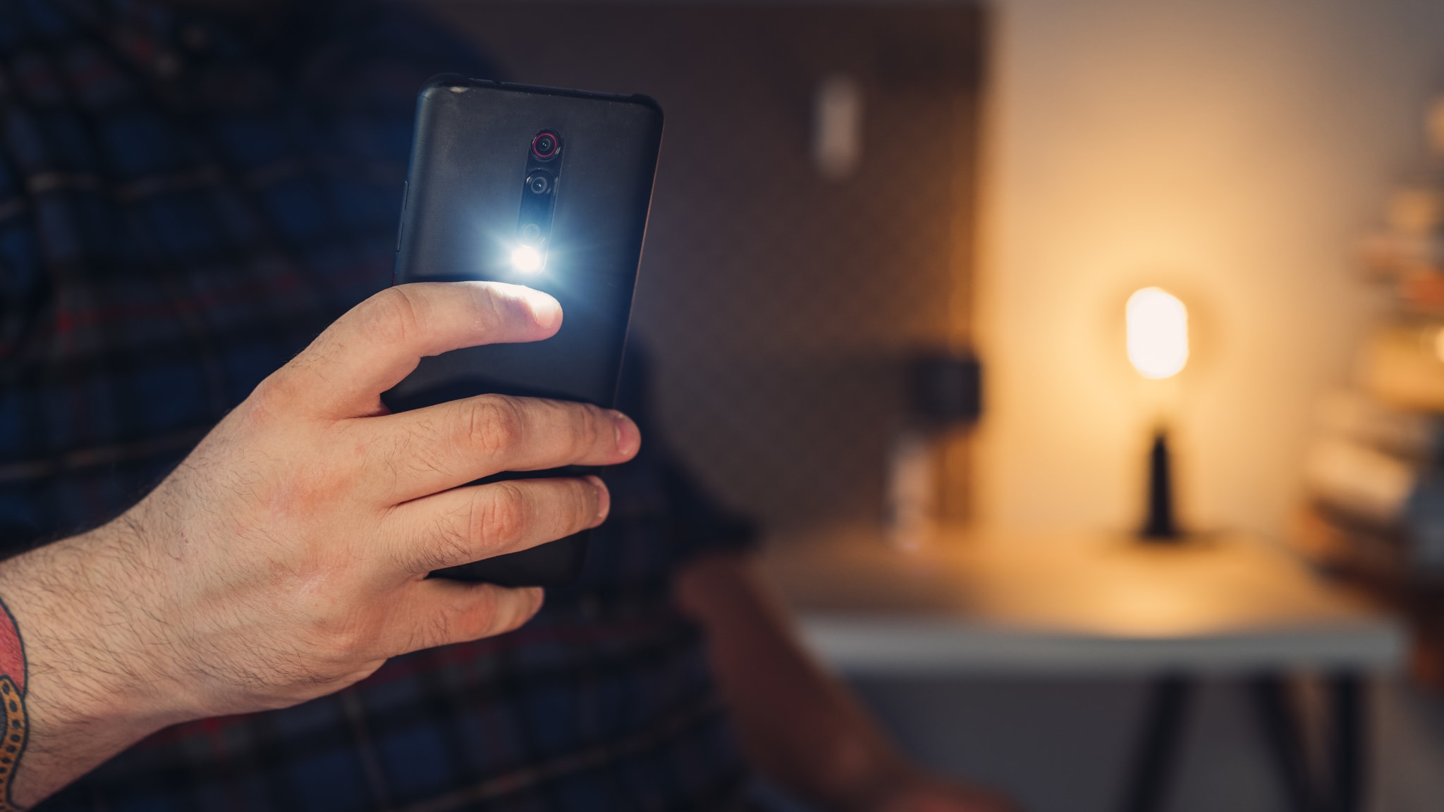 Ein Mann macht ein Foto mit einem Smartphone mit Blitz