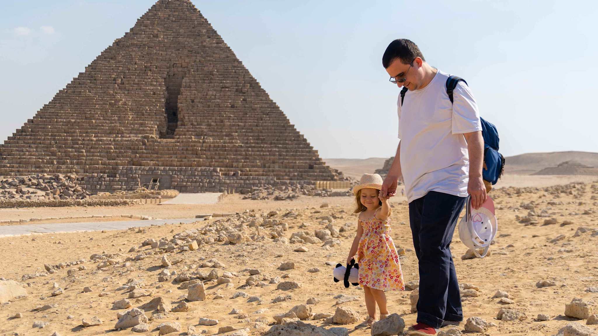 Ein Vater läuft mit seiner Tochter zur Pyramide von Gizeh.