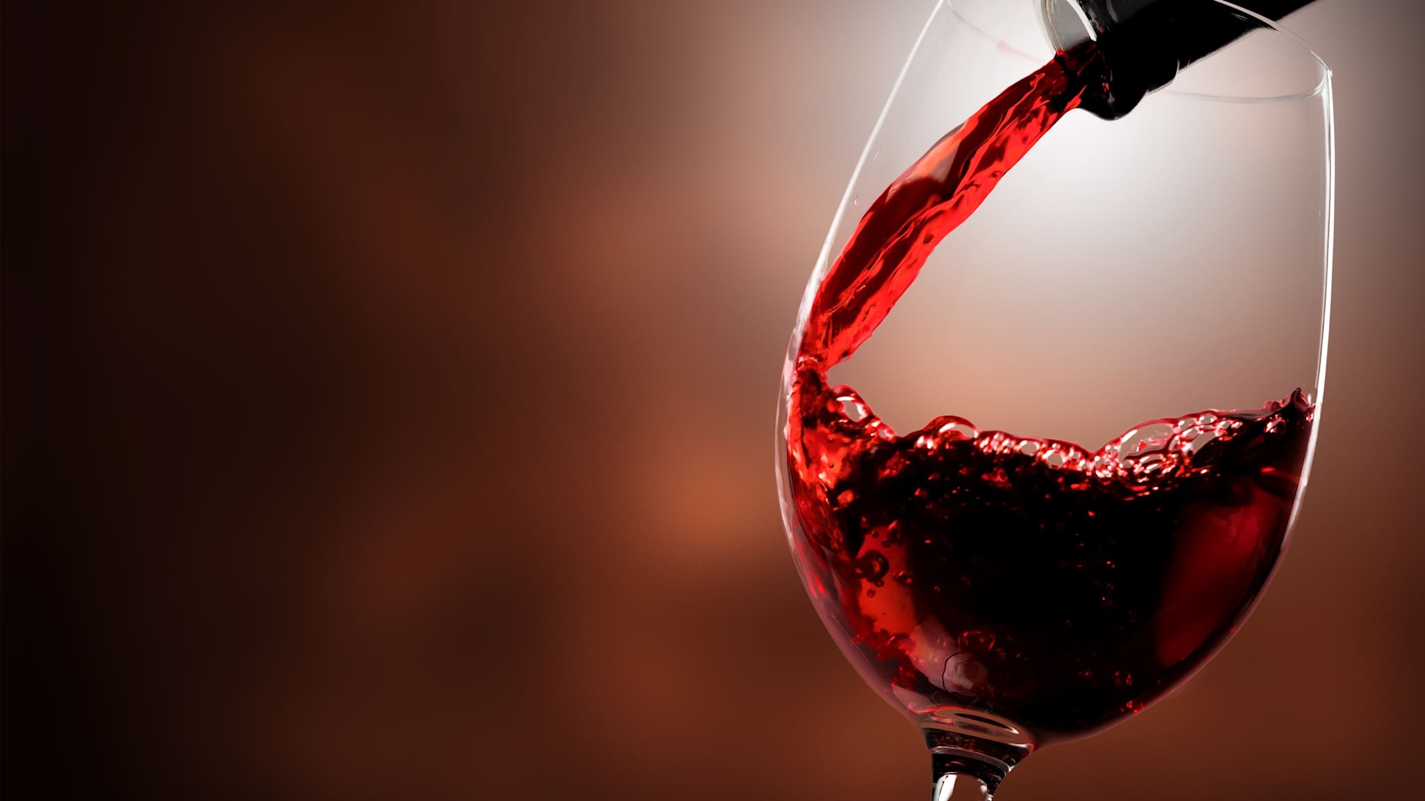 Wein fließt aus einer Flasche in ein Glas.