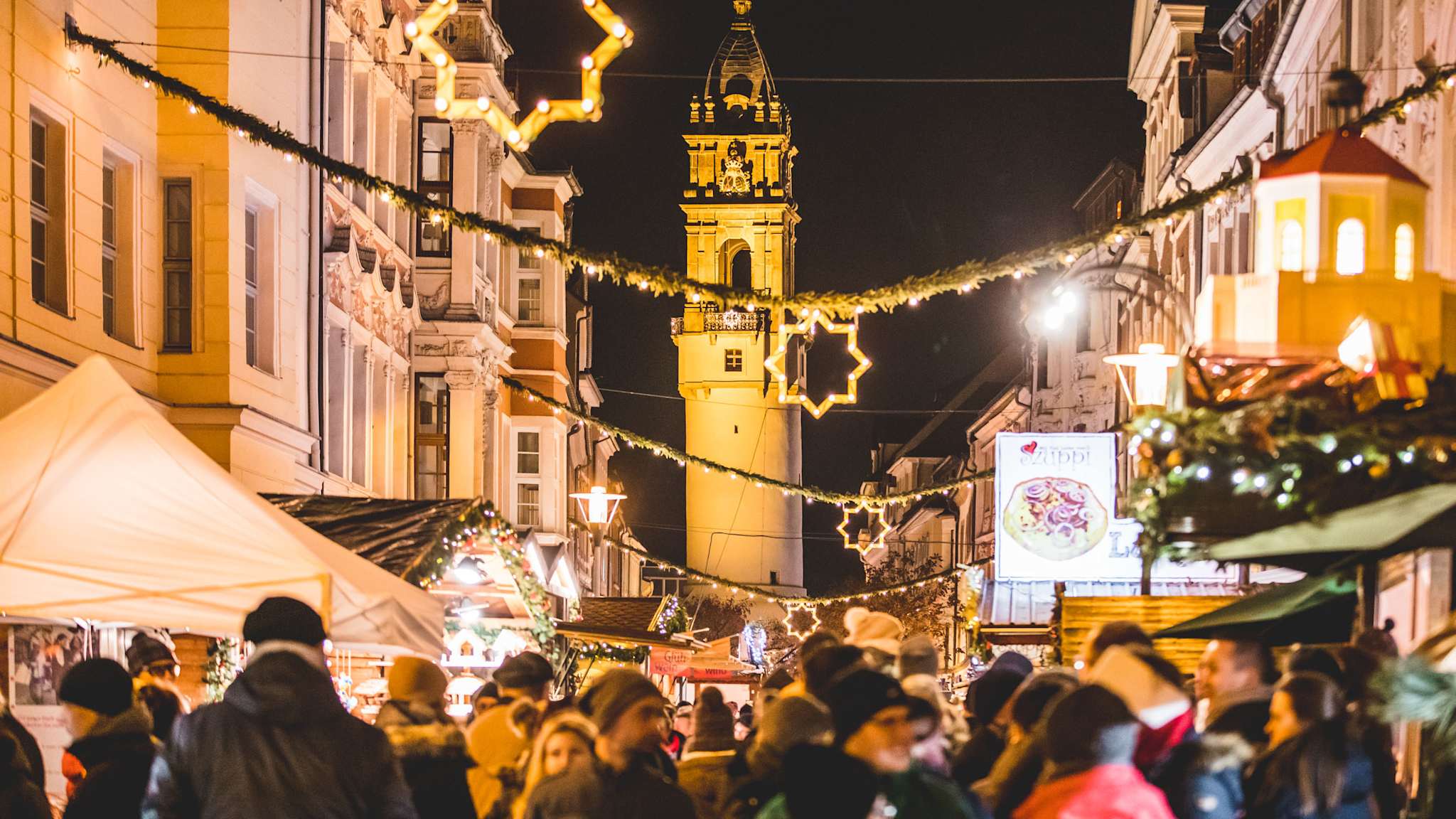 Menschen gehen über einen Weihnachtsmarkt.