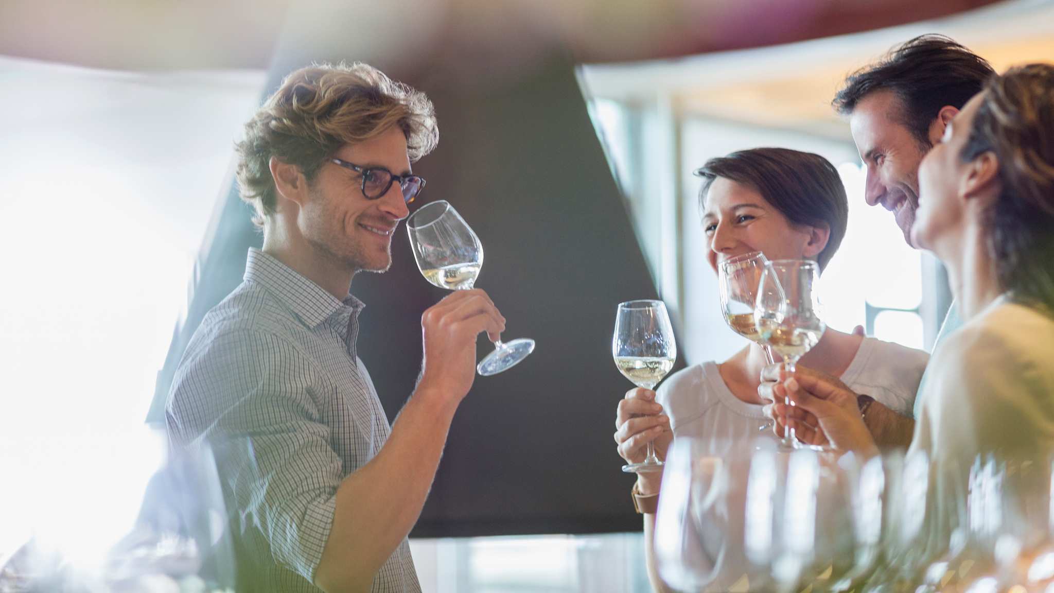 Eine Gruppe mit Weingläsern bei einem wine tasting.