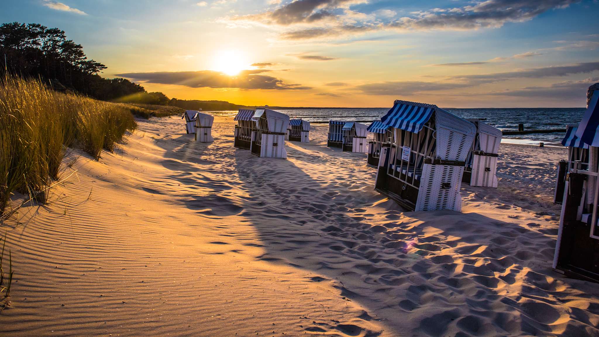 Strandkörbe bei Sonnenuntergang am Strand.
