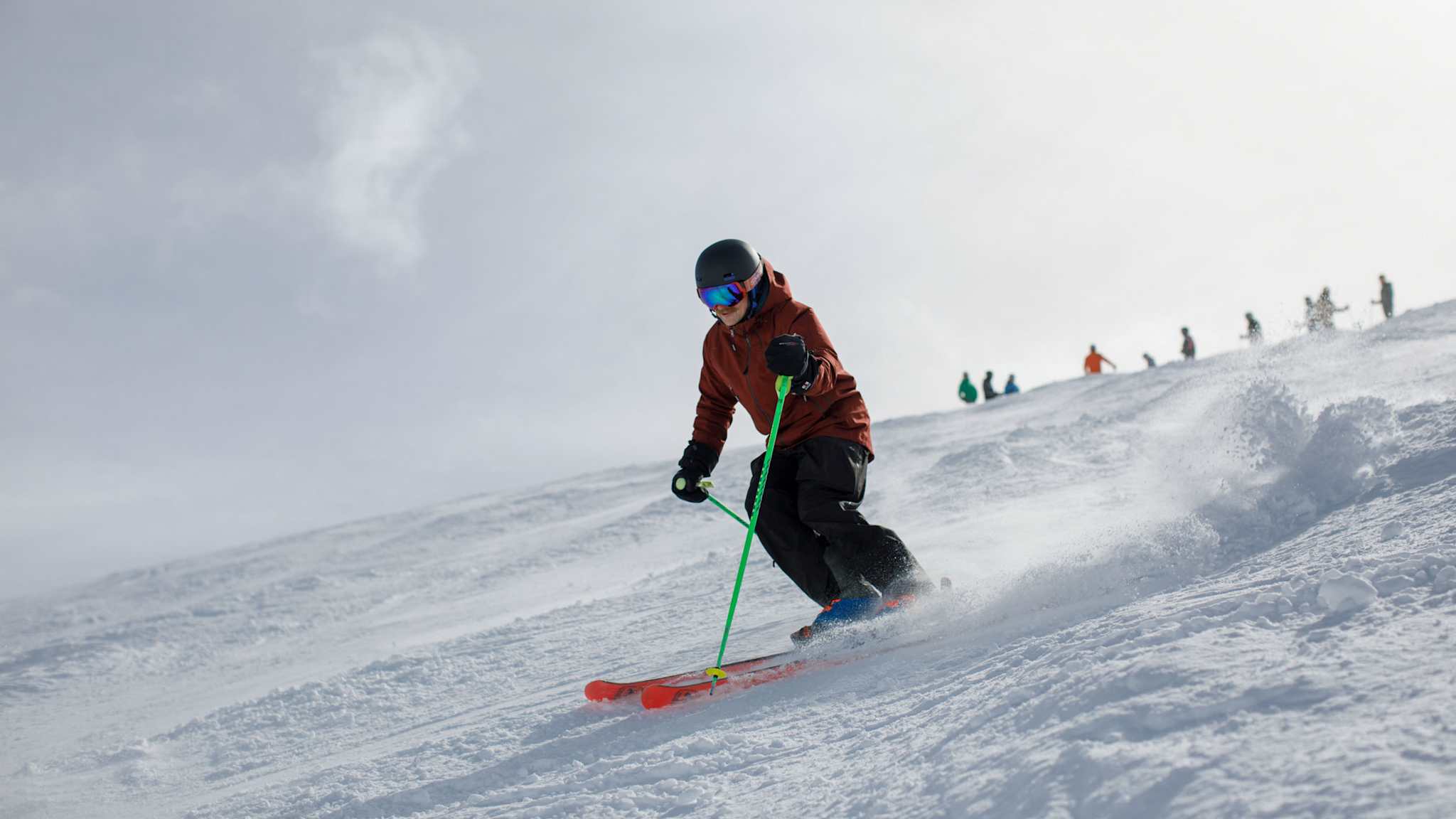 Eine Person fährt auf Skiern einen Hang hinunter.