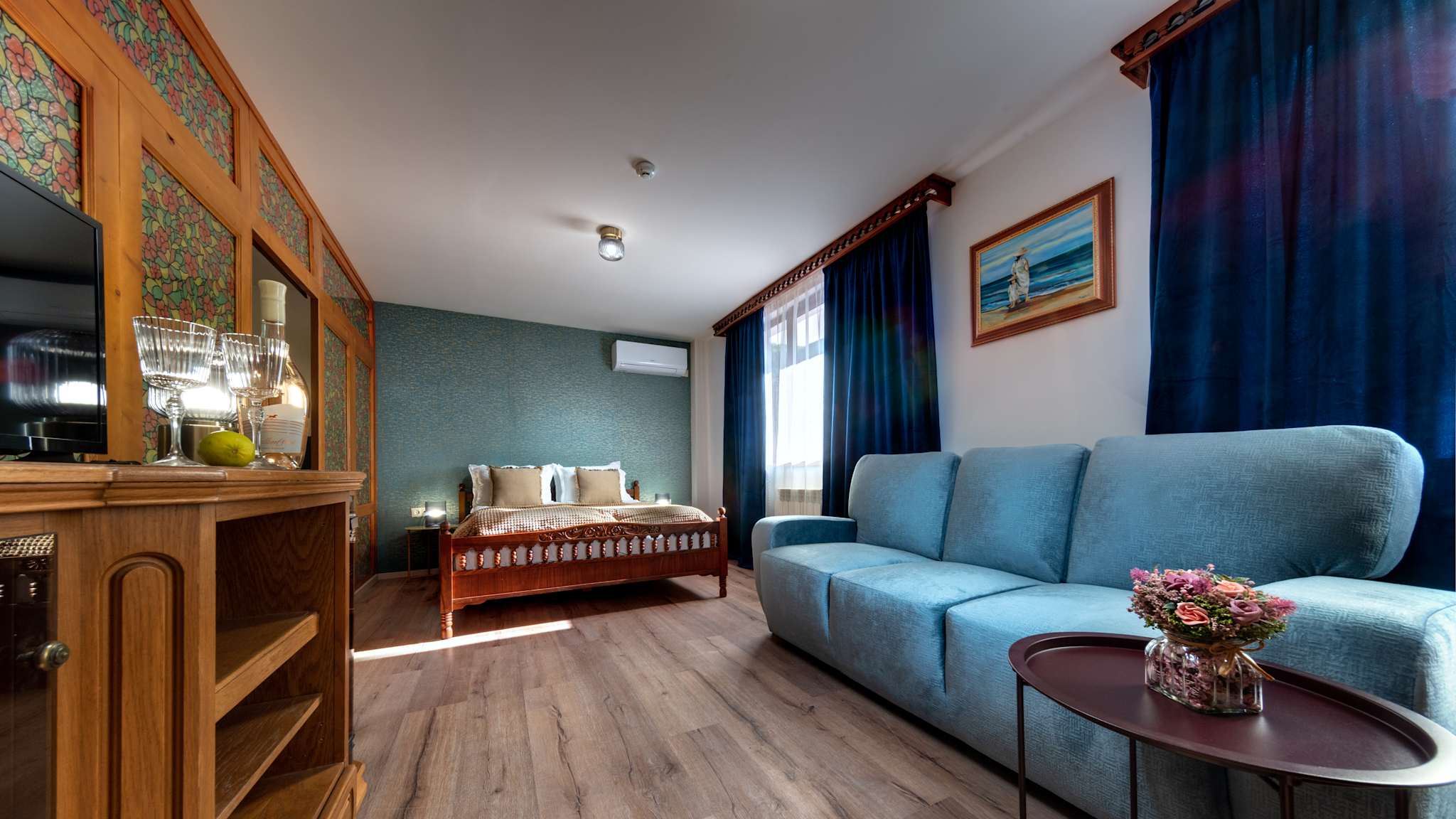 Ein Hotelzimmer mit einem Holzbett und einem Dreisitzersofa.