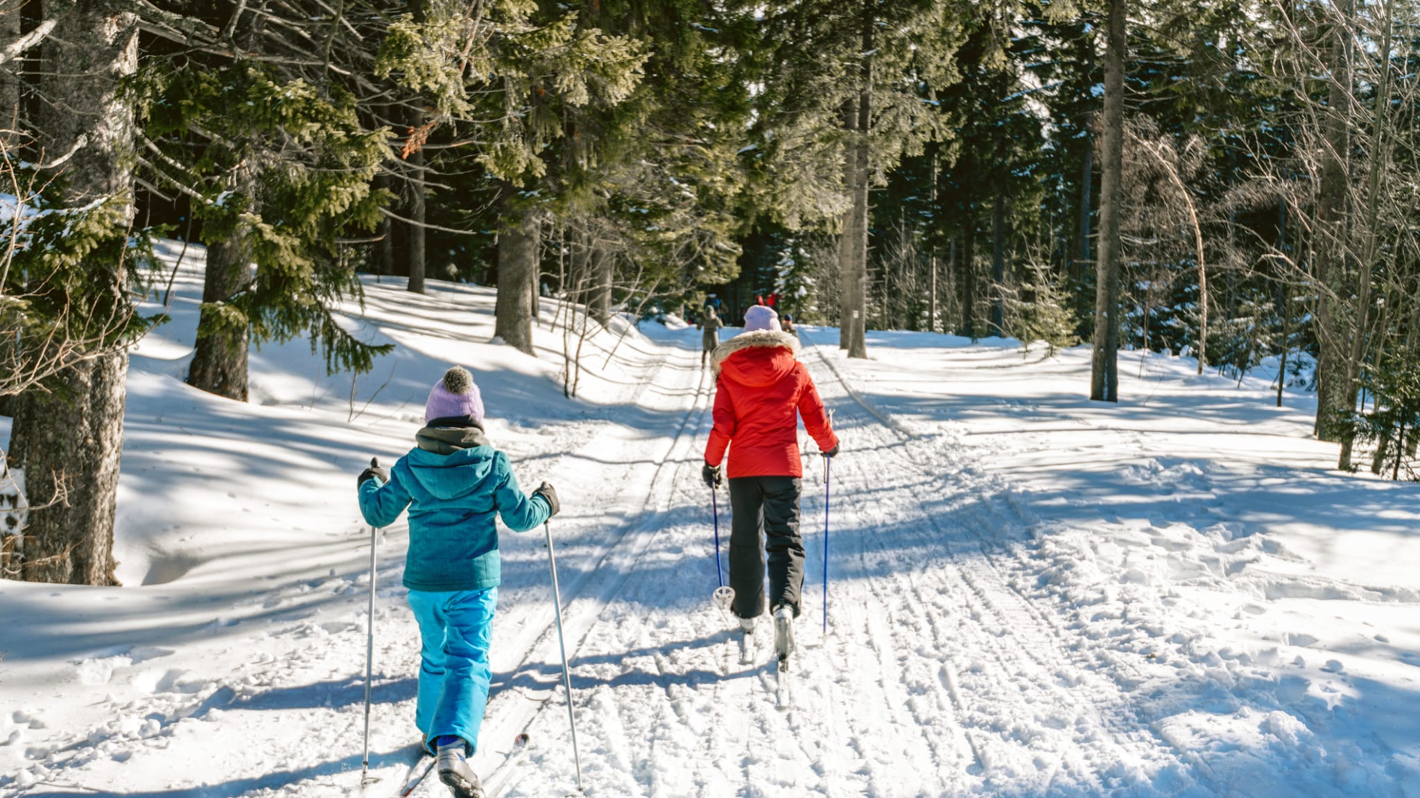 zwei Mädchen fahren Ski in verschneiter Winterlandschaft