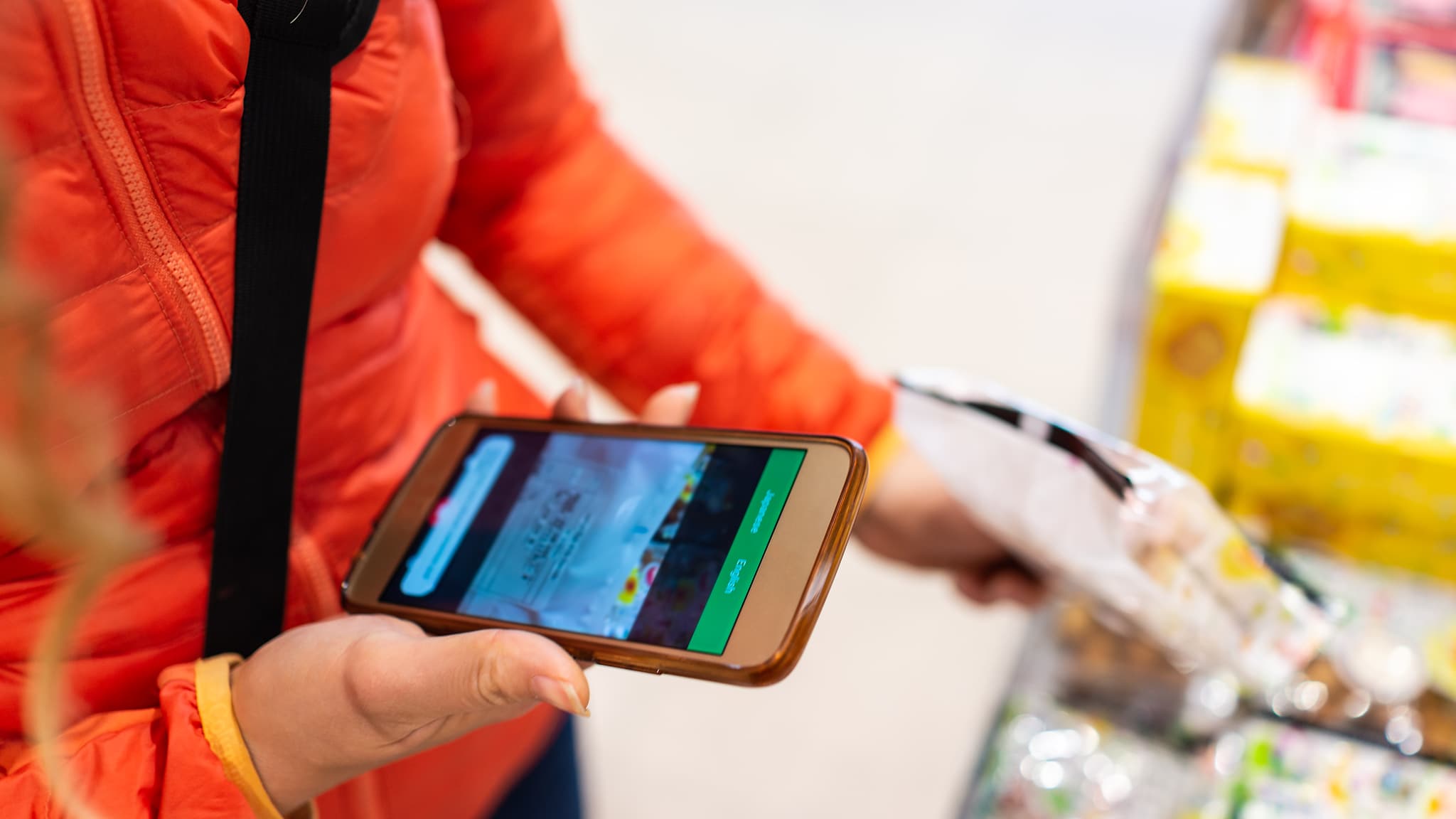 Frau benutzt eine Übersetzungsapp für Verpackungen in japanischem Supermarkt
