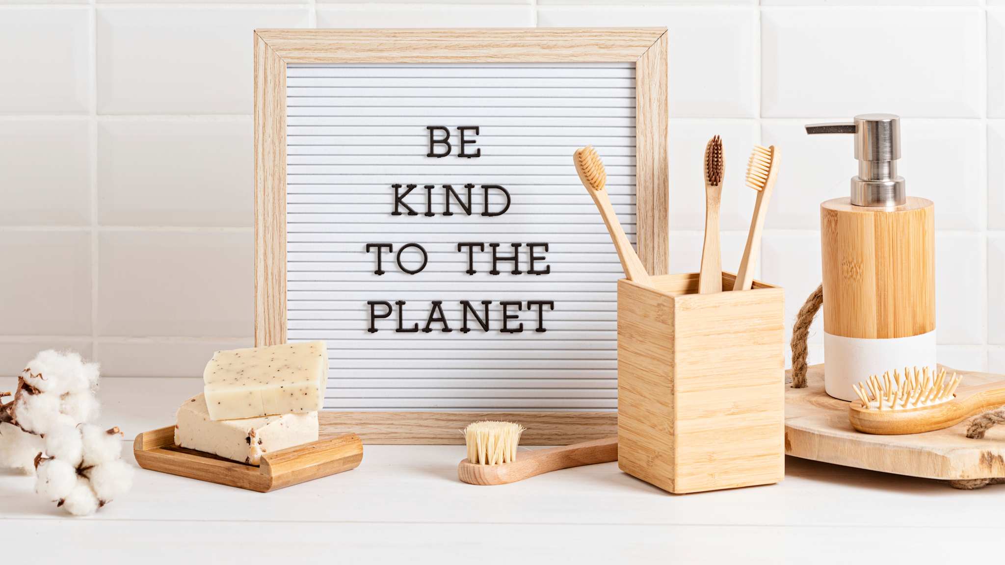 Badezimmer Hotel mit nachhaltigem Bad-Zubehör und Schild mit Text Be kind to the Planet