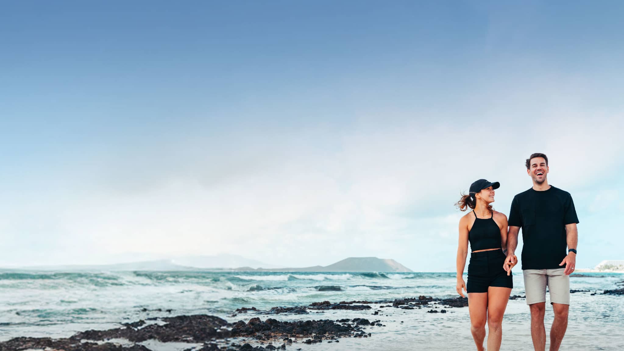 Ein Paar geht am Strand spazieren.