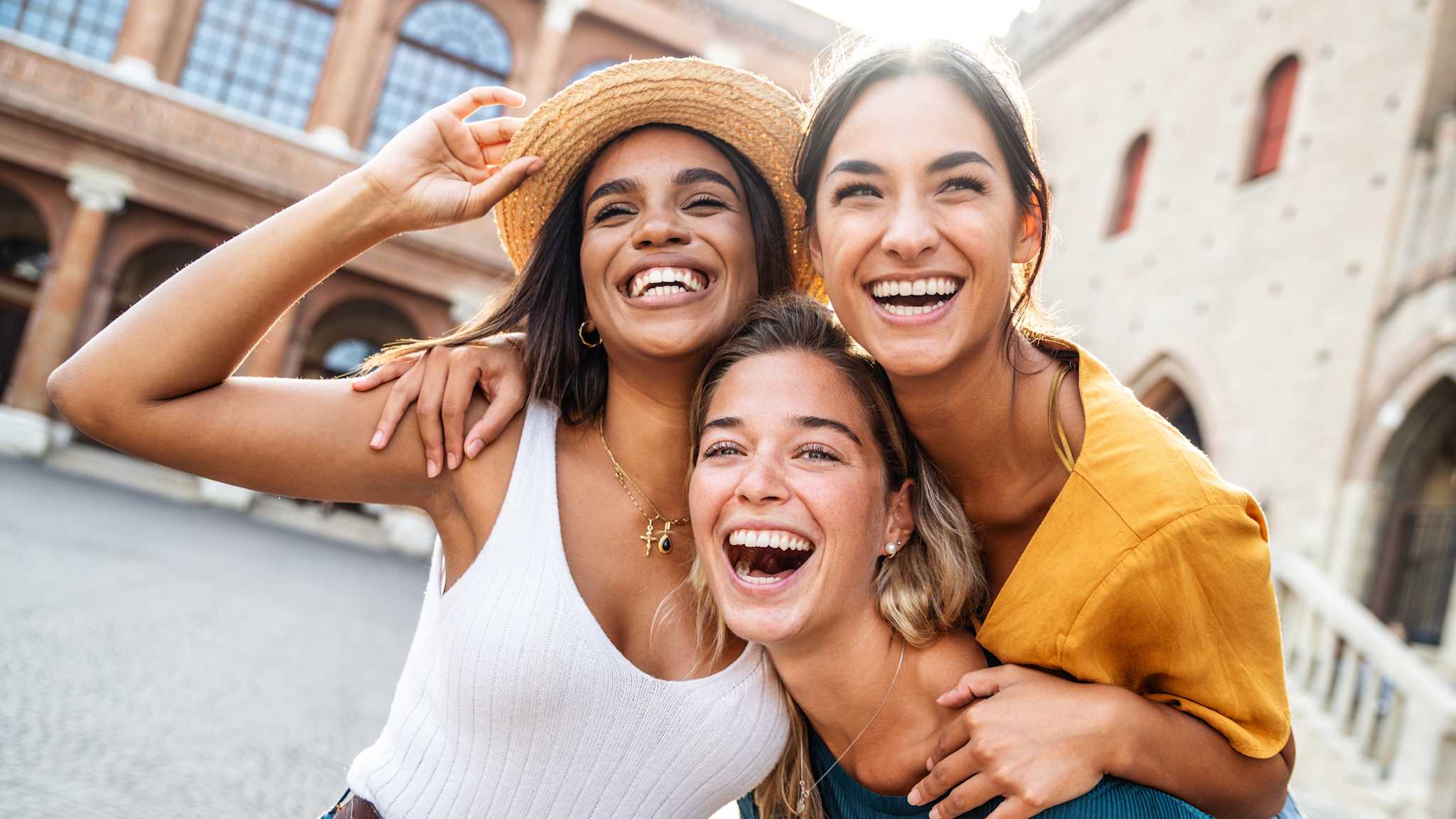 Drei Frauen strahlen in die Kamera