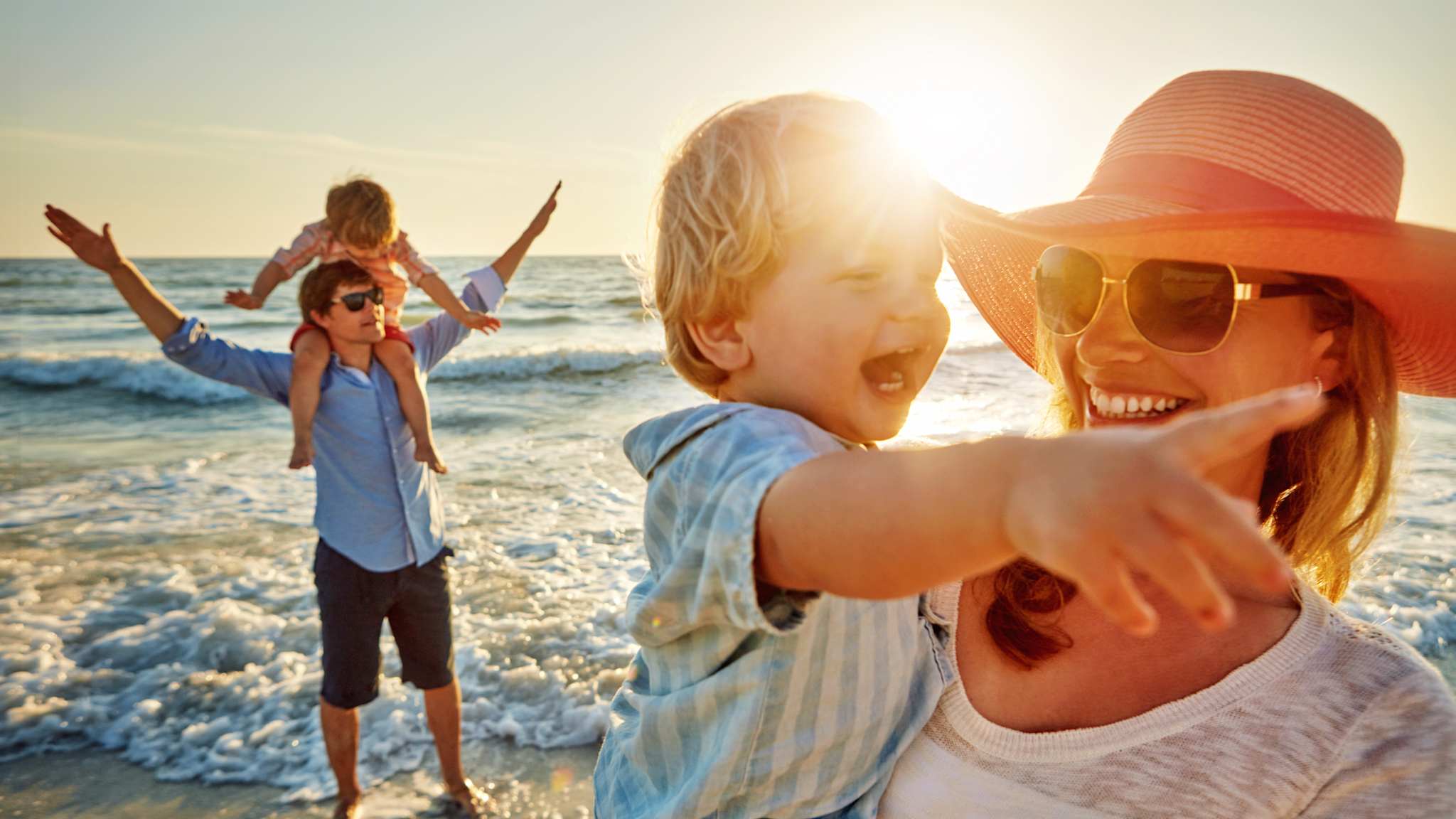 Glückliche Familie am Strand im Sonnenschein