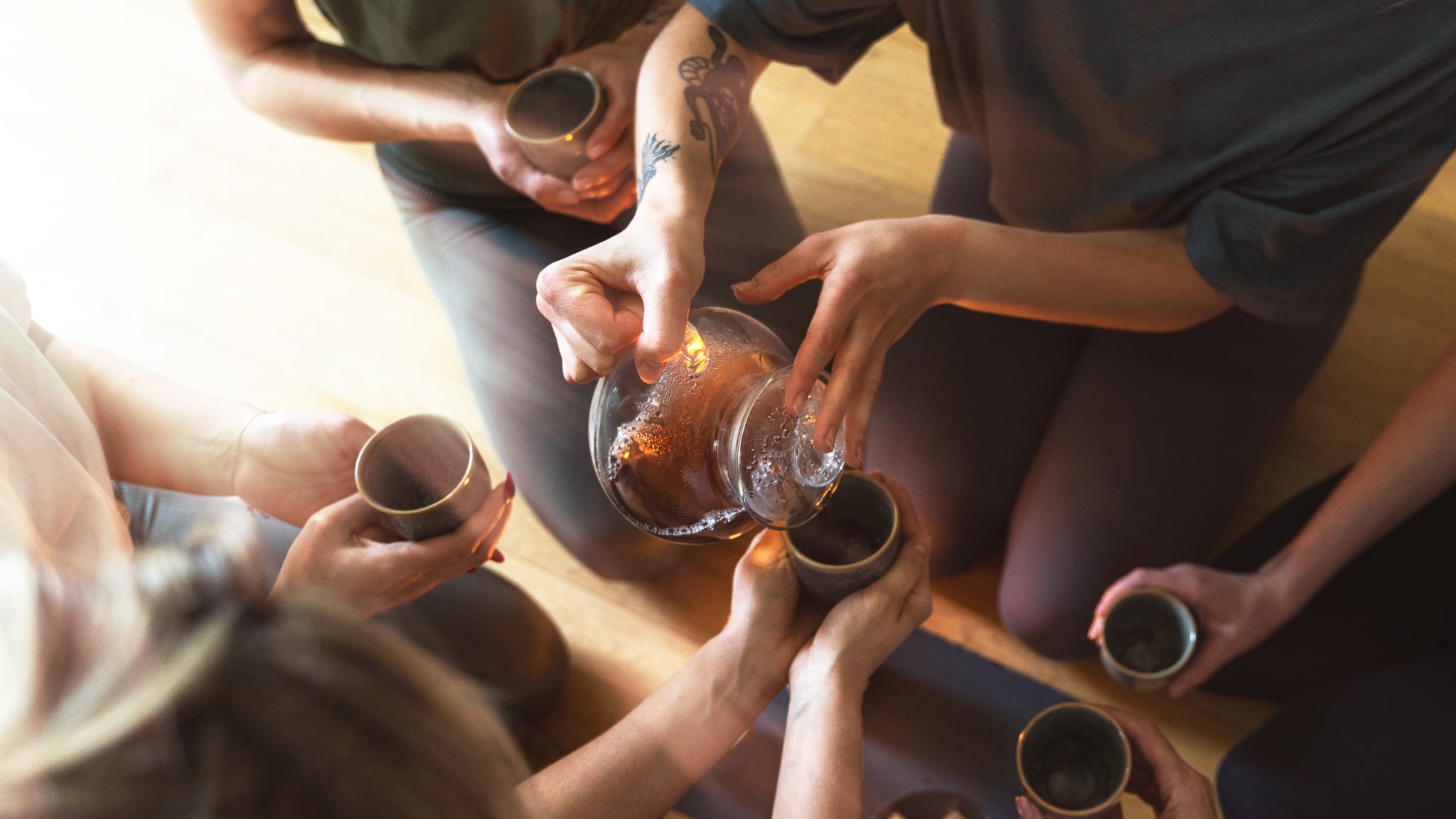 Frau gießt in einer Runde Tee ein.