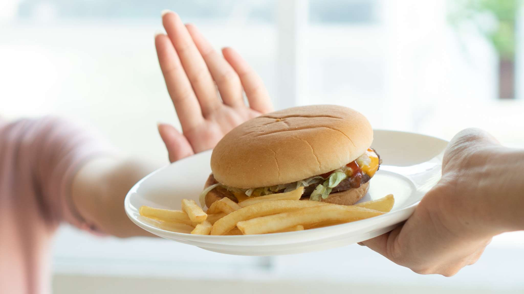Eine Frau möchte keinen Burger mit Pommes.