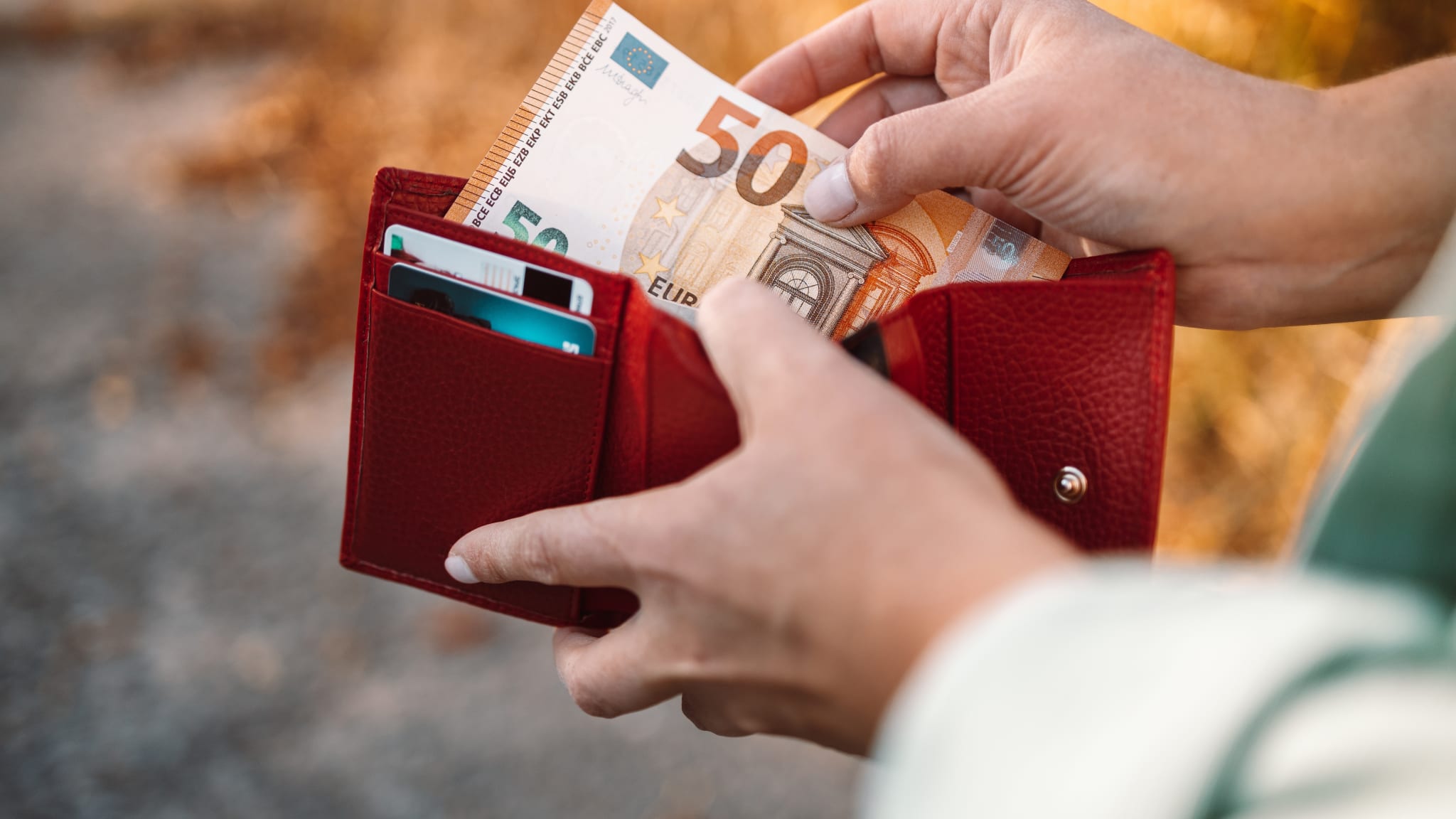 Frau greift nach Geld, 50 Euro.