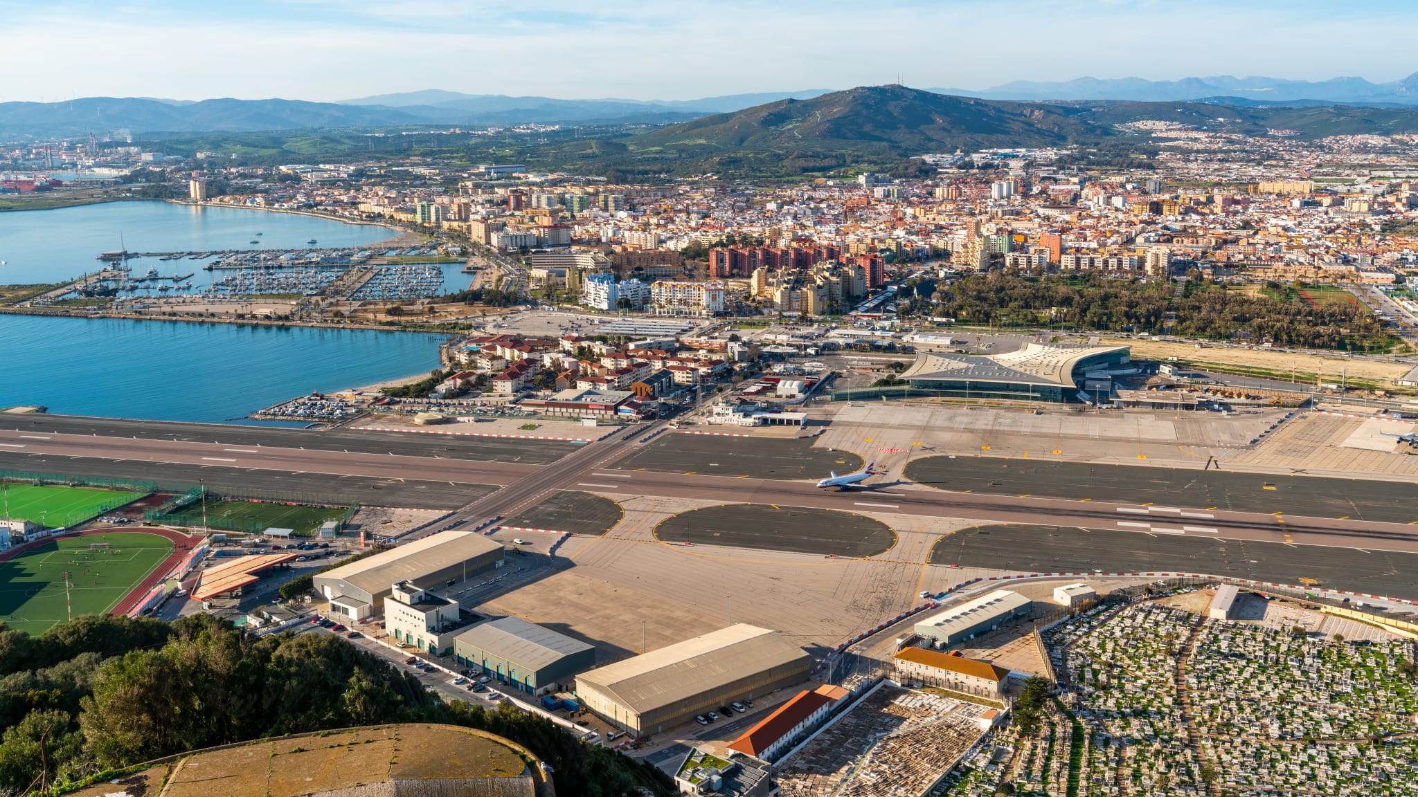 Blick von oben auf den Flughafen von Gibraltar. Eine Straße kreuzt den Runway.