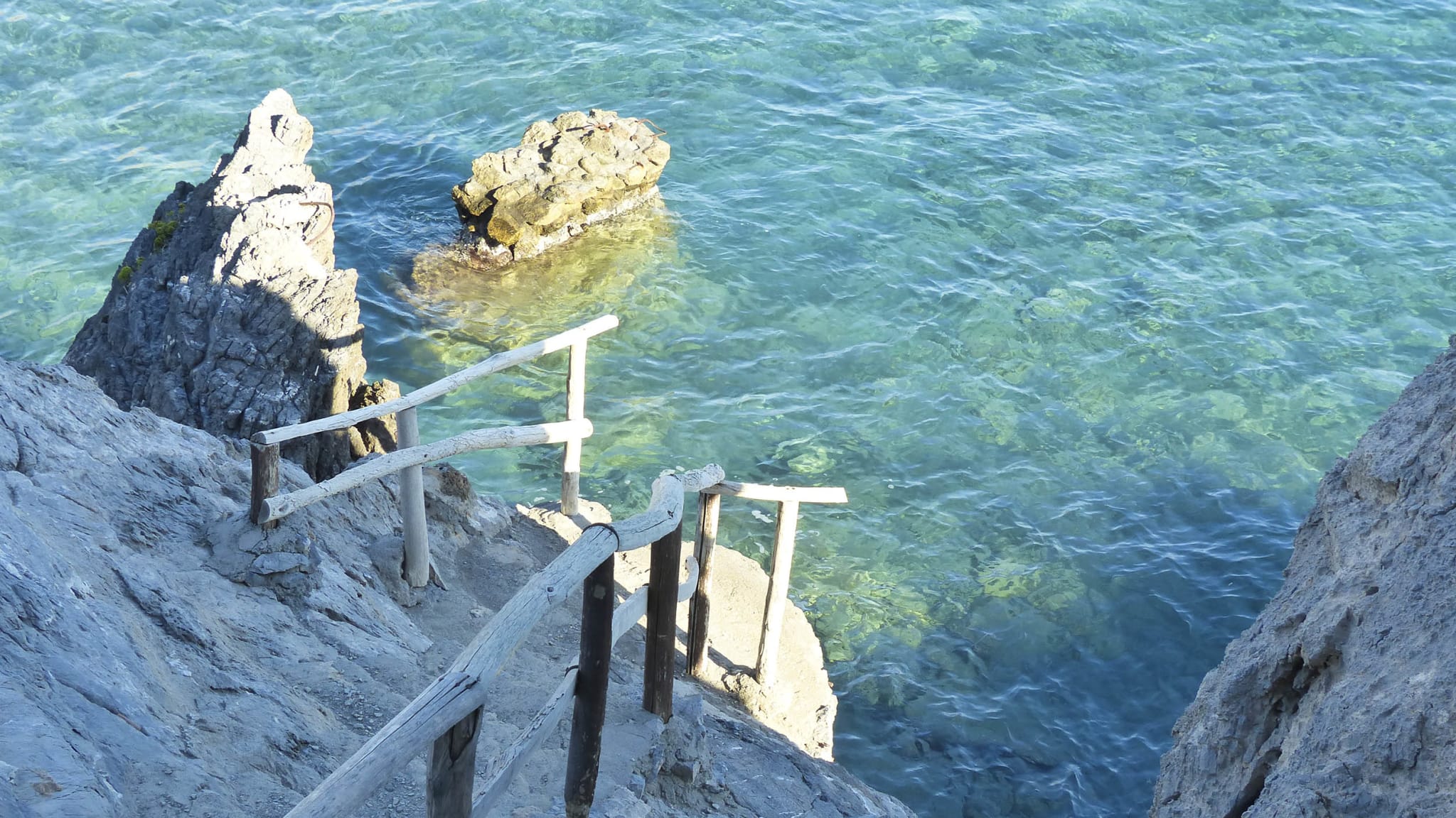 Schmale Wege führen über die Felsen am Strand