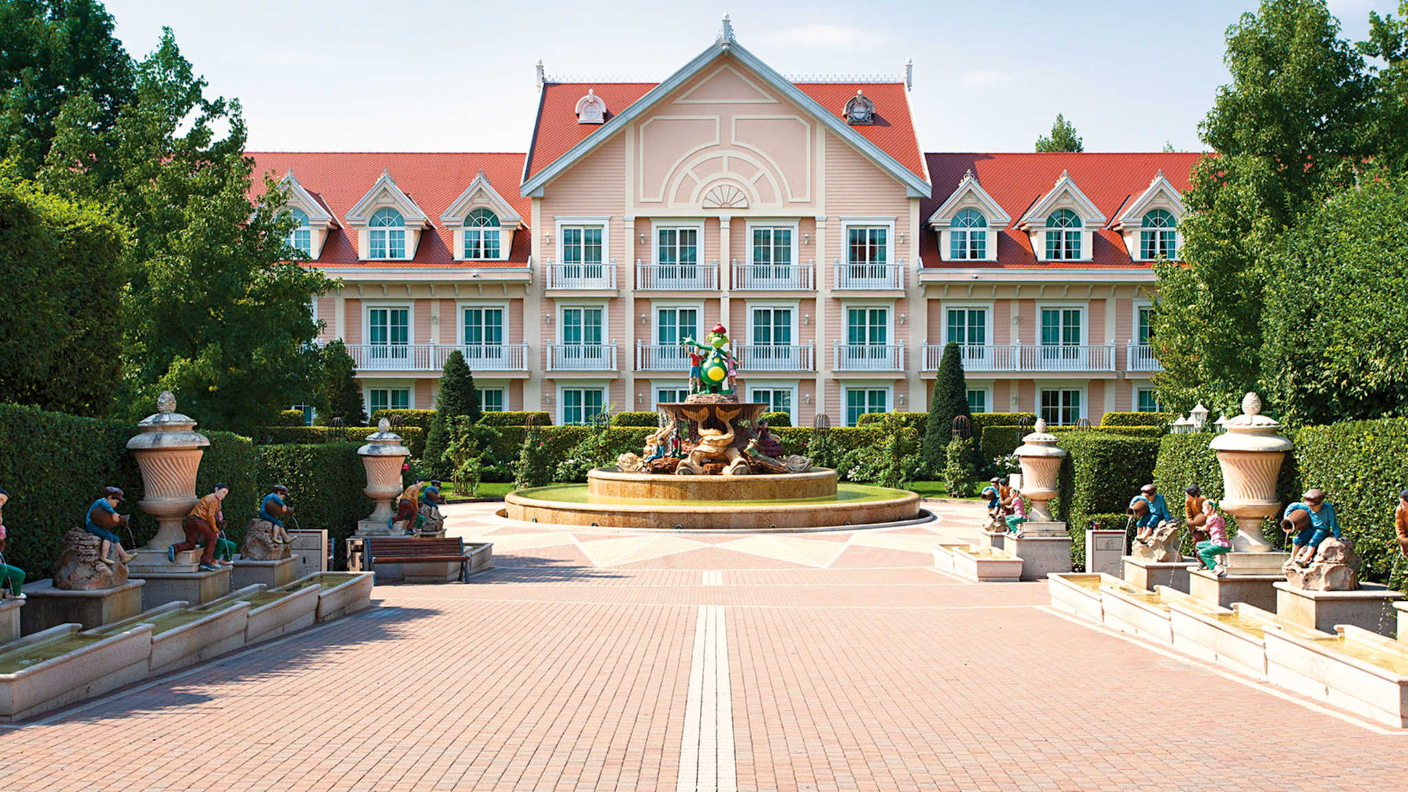 Blick auf das Gardaland Hotel mit großem Brunnen und Maskottchen des Gardalands