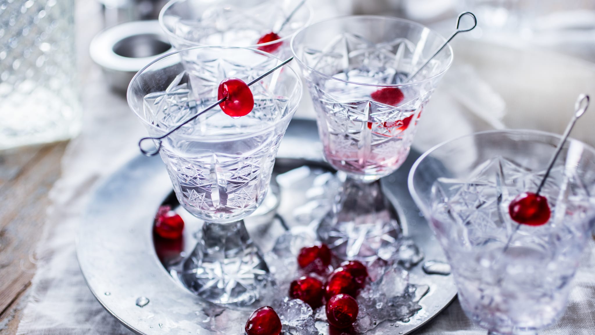 Aufgespießte Maraschino-Kirschen in Kristallgläsern auf einem silbernem Tablett