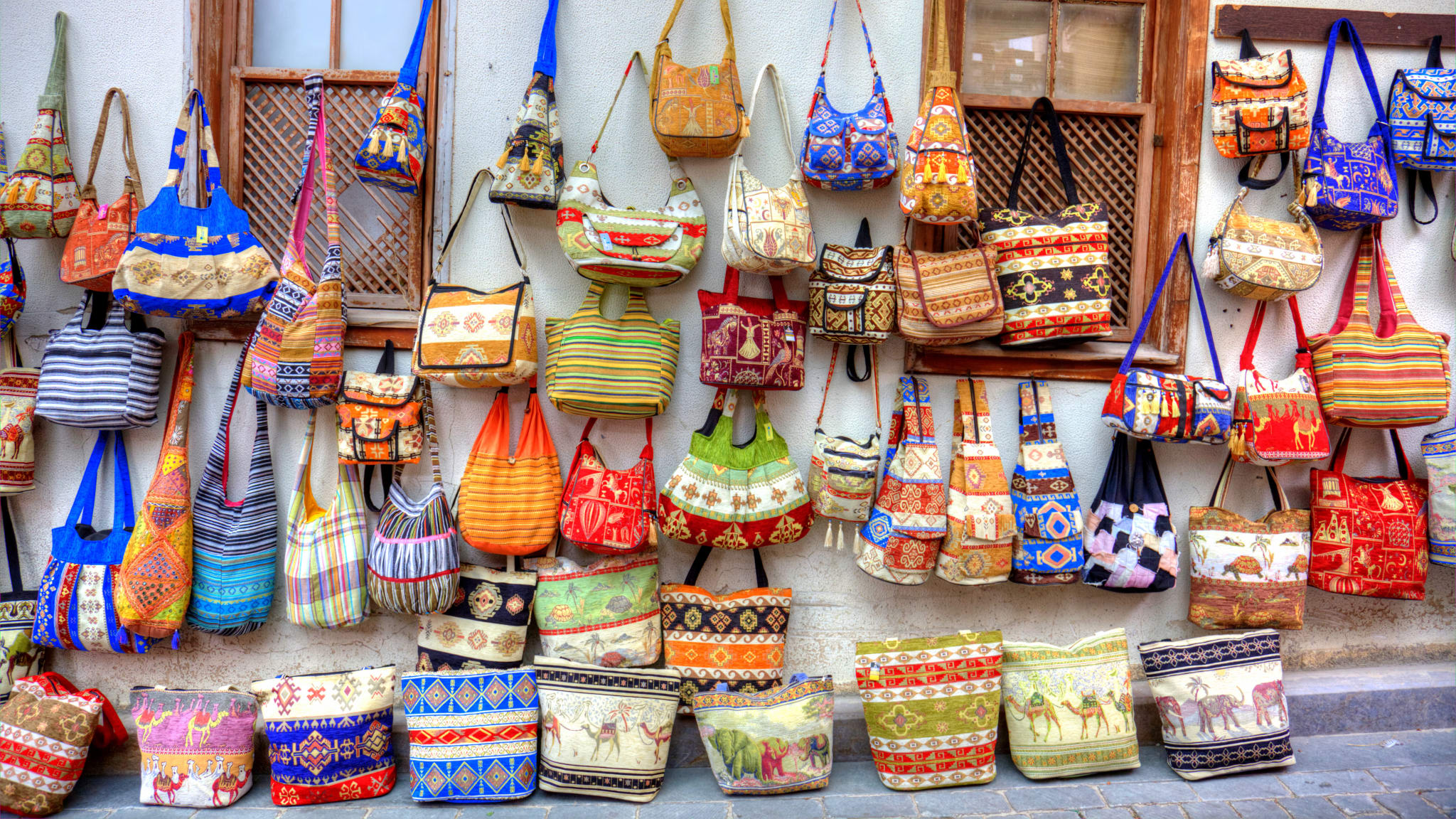 Großes Taschensortiment, an einer Hauswand aufgehängt, auf einem Markt in Antalya