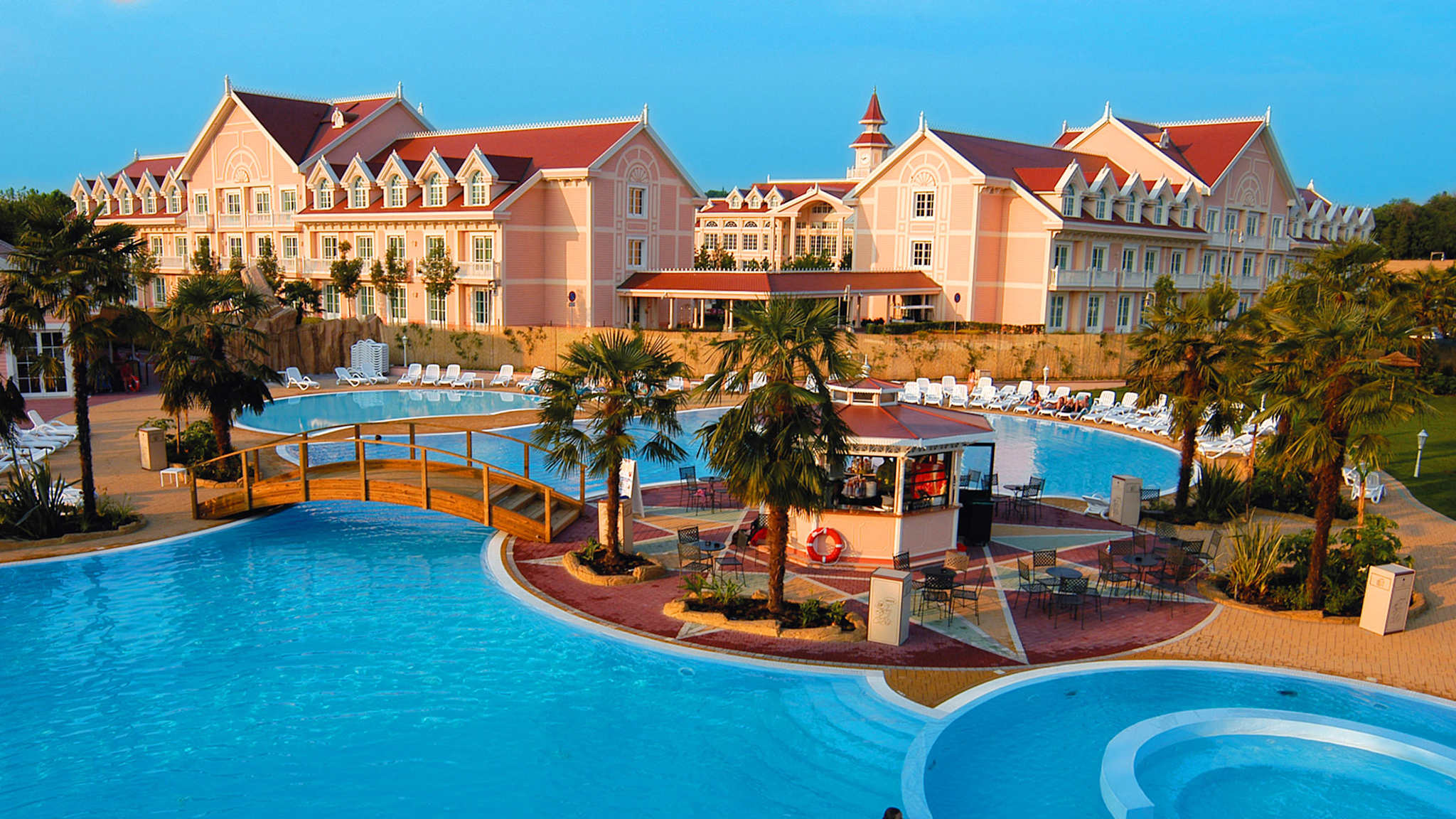Blauer Pool mit Hotelanlage dahinter