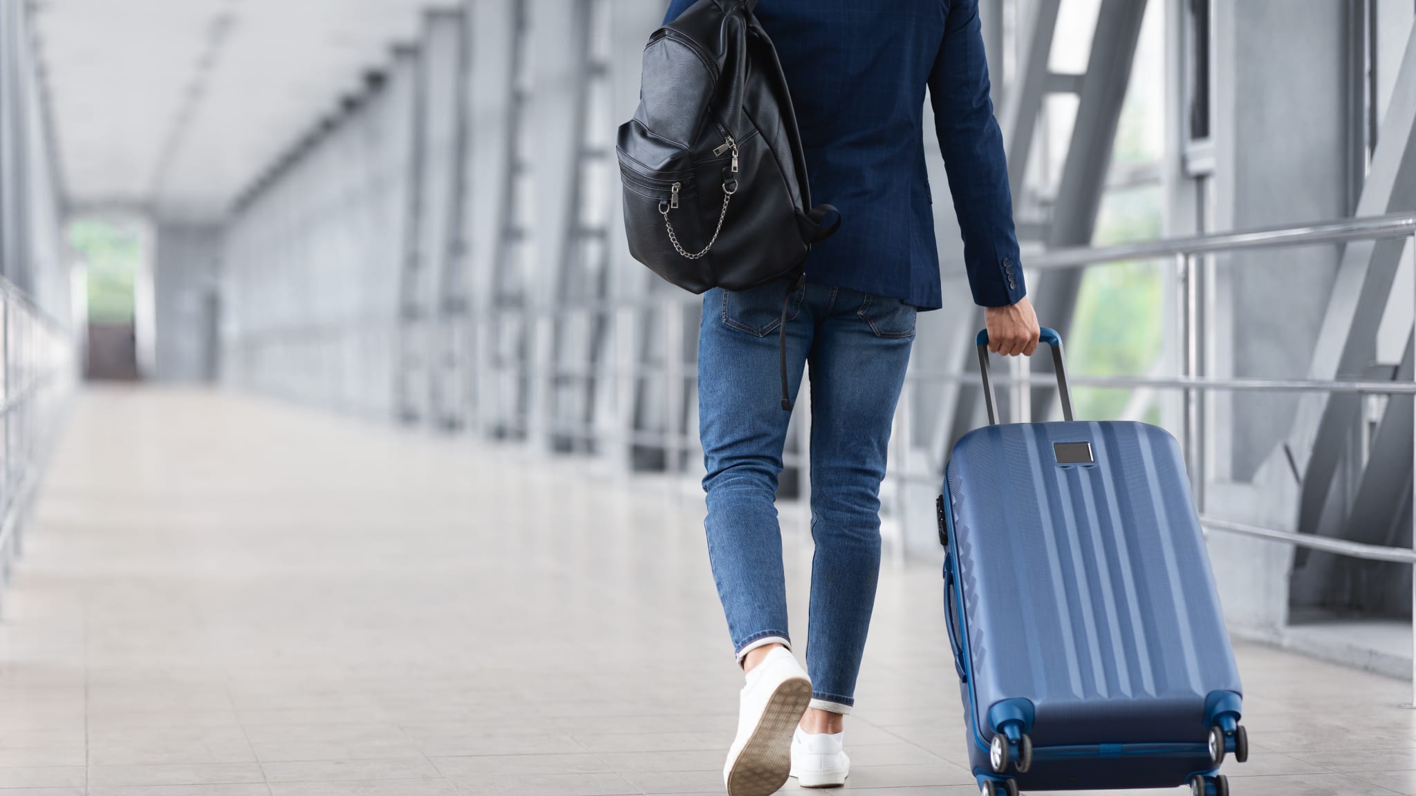 Mann mit Rollkoffer am Flughafen