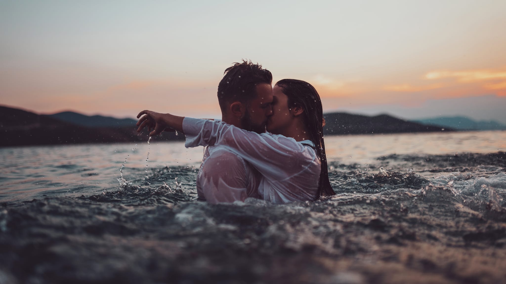 Paar küsst sich leidenschaftlich im Meer.