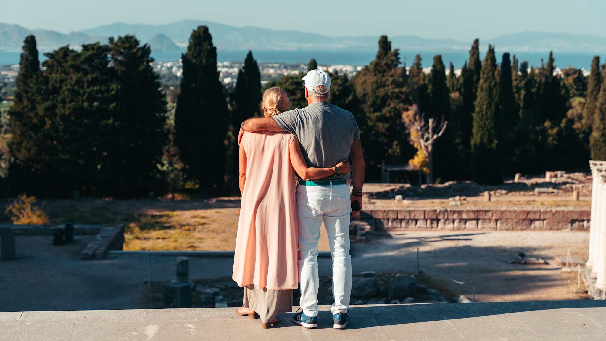 Älteres Paar von hinten mit Blick auf die Landschaft von Kos, Griechenland.