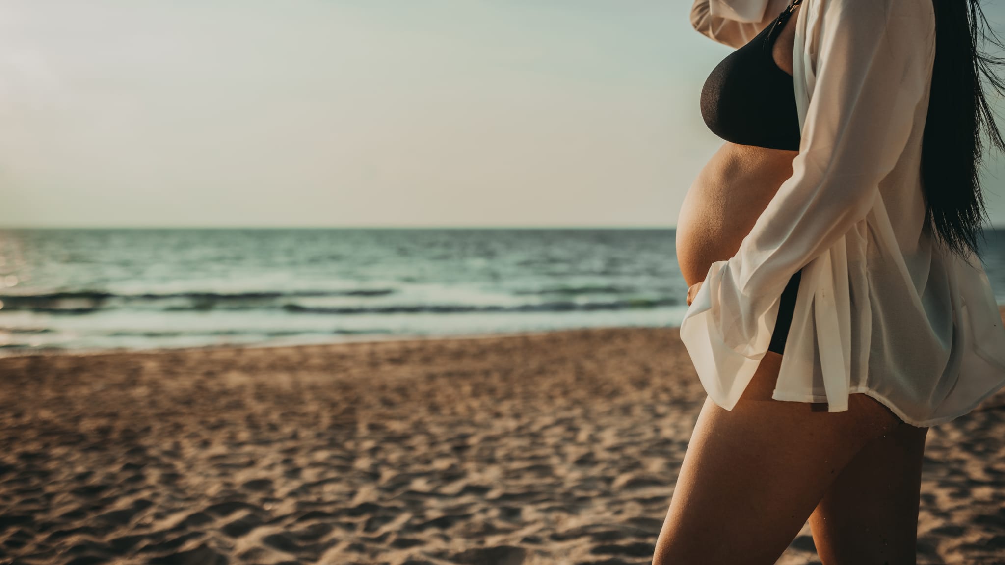 Schwangere Frau am Strand.