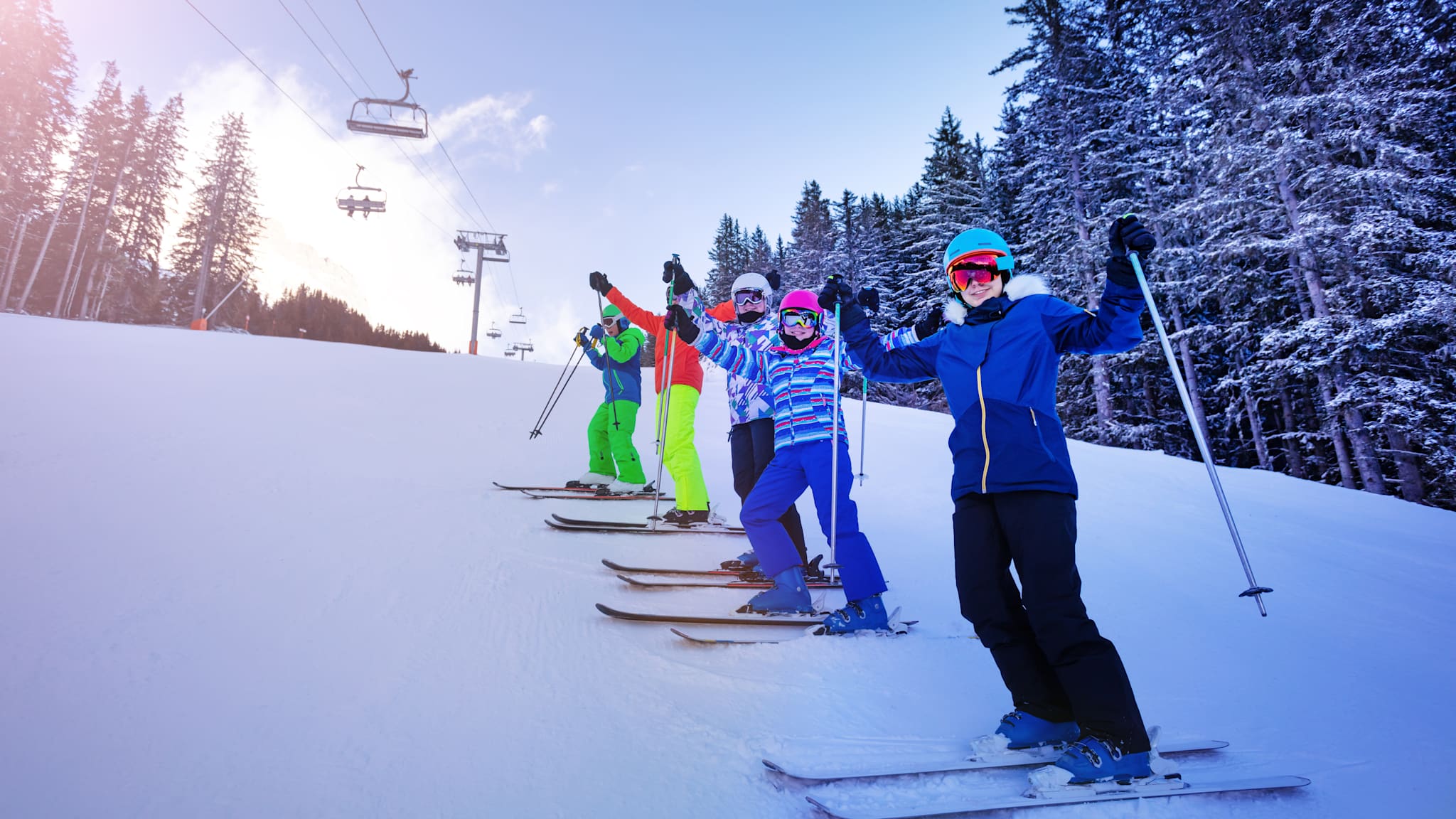 Skischüler stehen am Hang auf der schneebedeckten Piste.