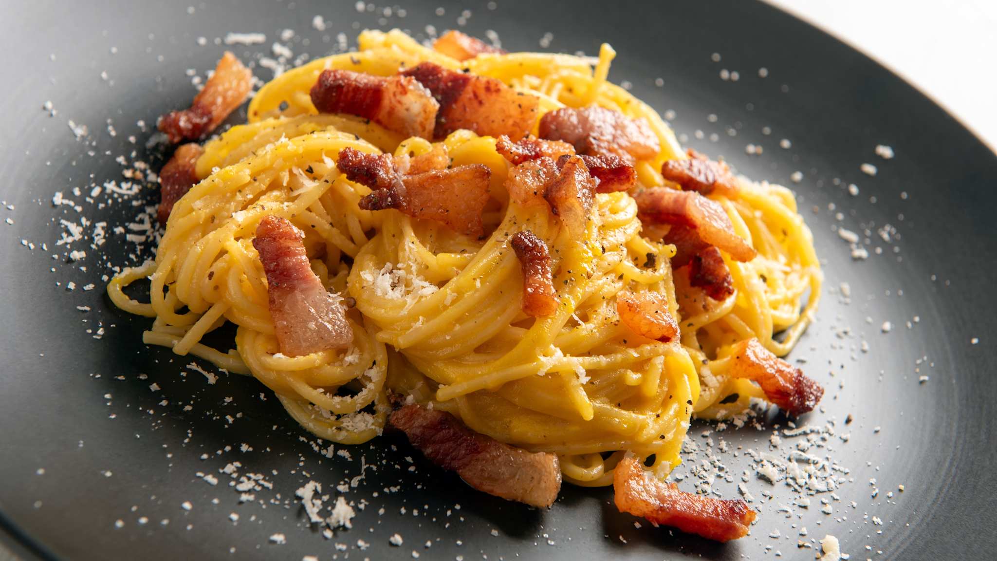 Spaghetti alla Carbonara auf einem schwarze Teller.
