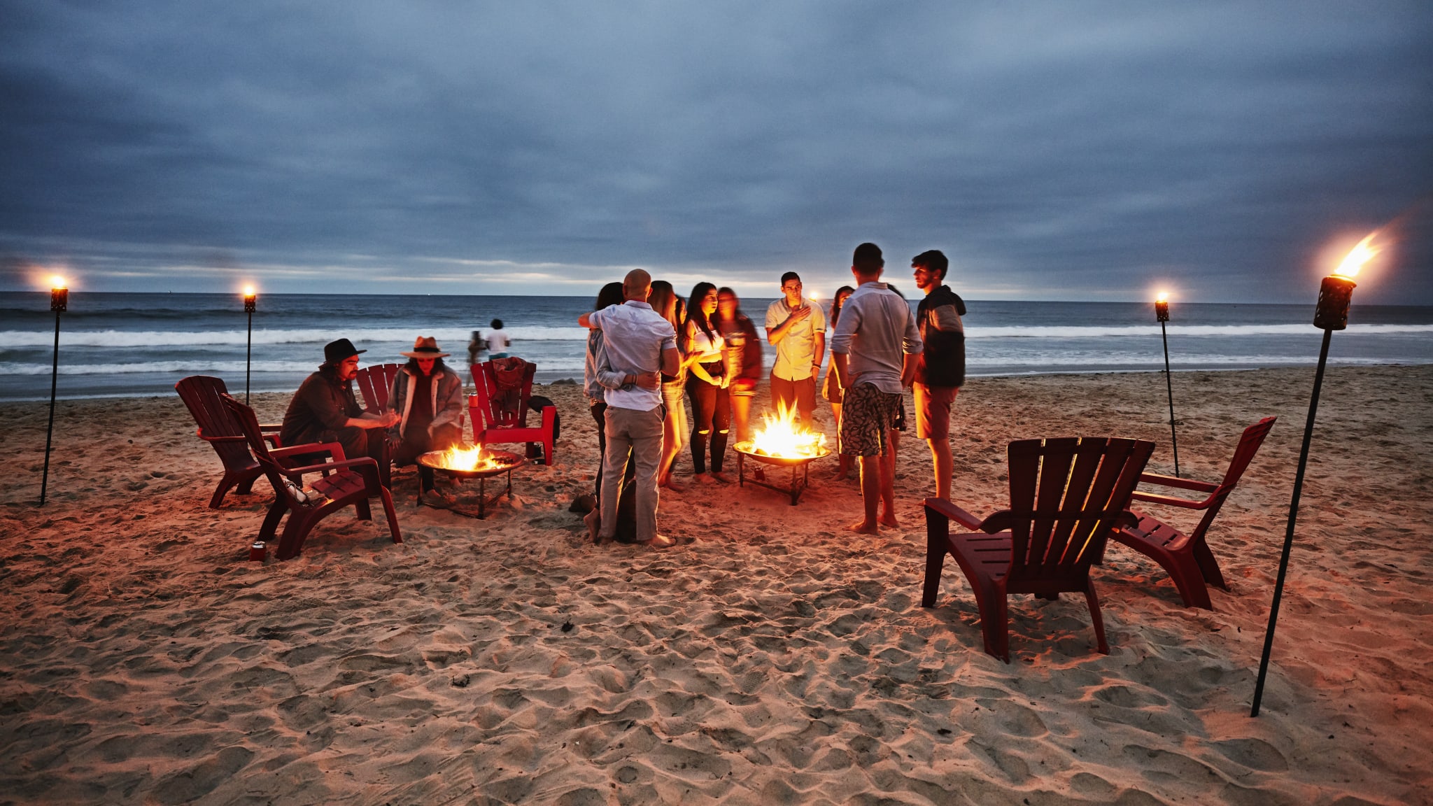 Freunde feiern am Strand mit Lagerfeuer