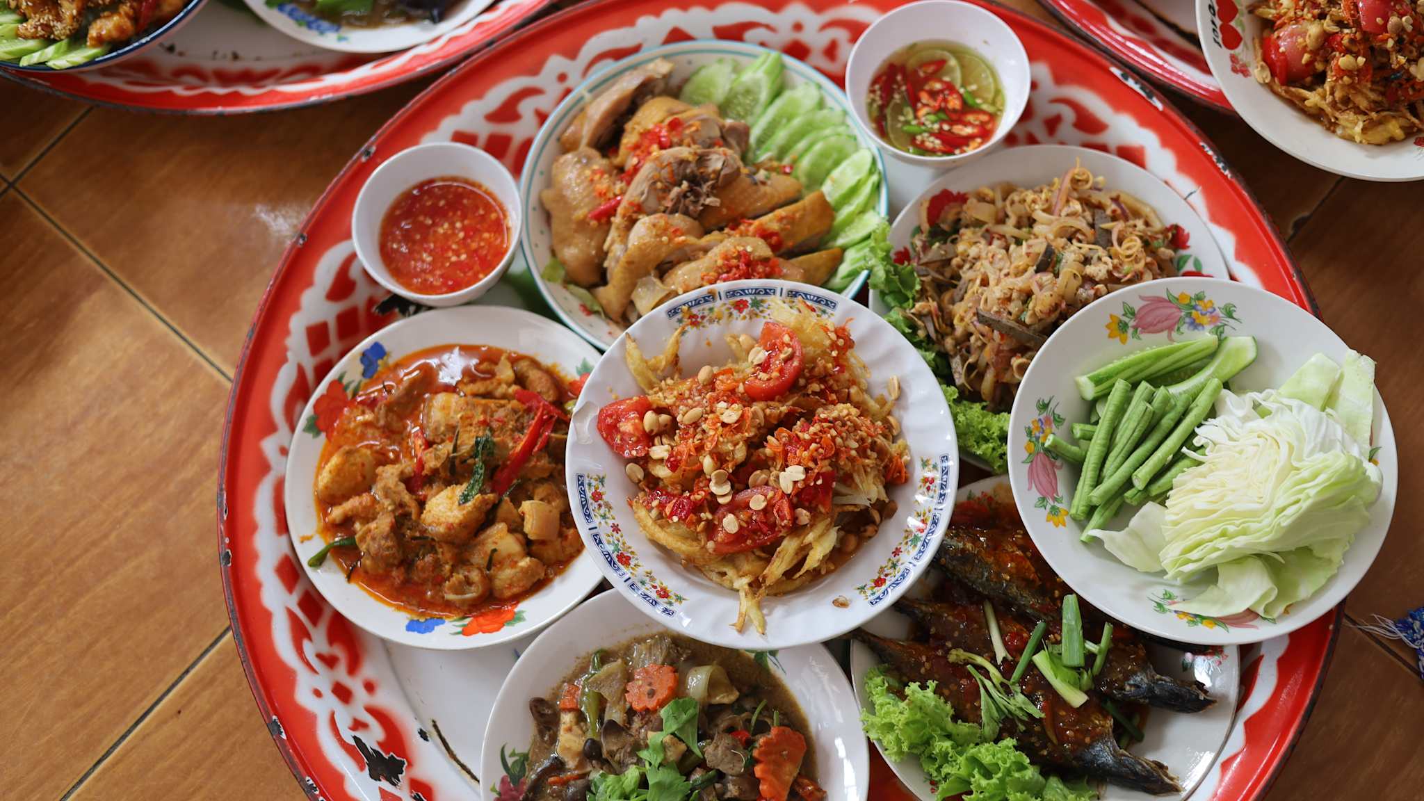 Ein Tablet mit vielen Tellern mit unterschiedlichen thailändischen Spesien.