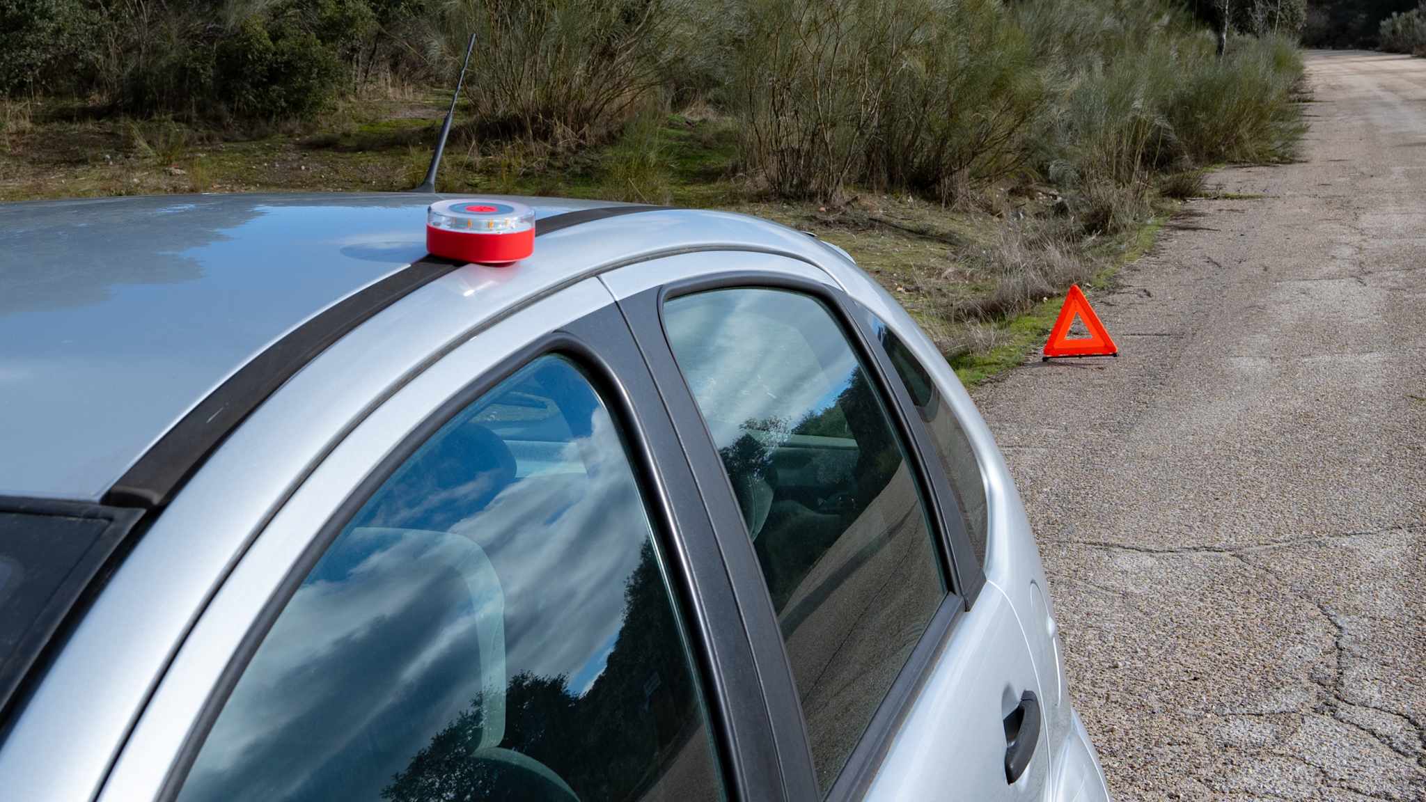 Warnleuchte und Warndreieck auf der Straße bei einem Unfall