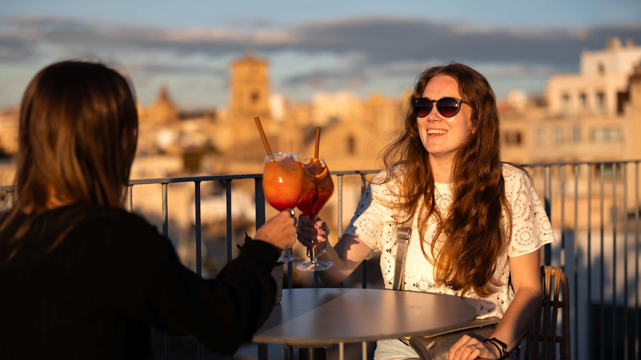 Zwei Frauen stoßen mit einem Aperol an