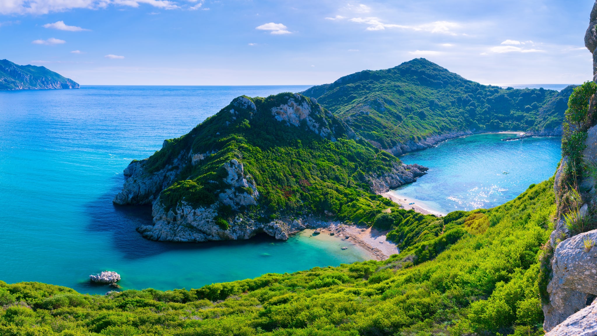 Beautiful summertime panoramic seascape. View of the cliff into the crystal clear azure sea bay and distant islands. Unique secluded beach. Agios Stefanos cape. Afionas. Corfu. Greece.