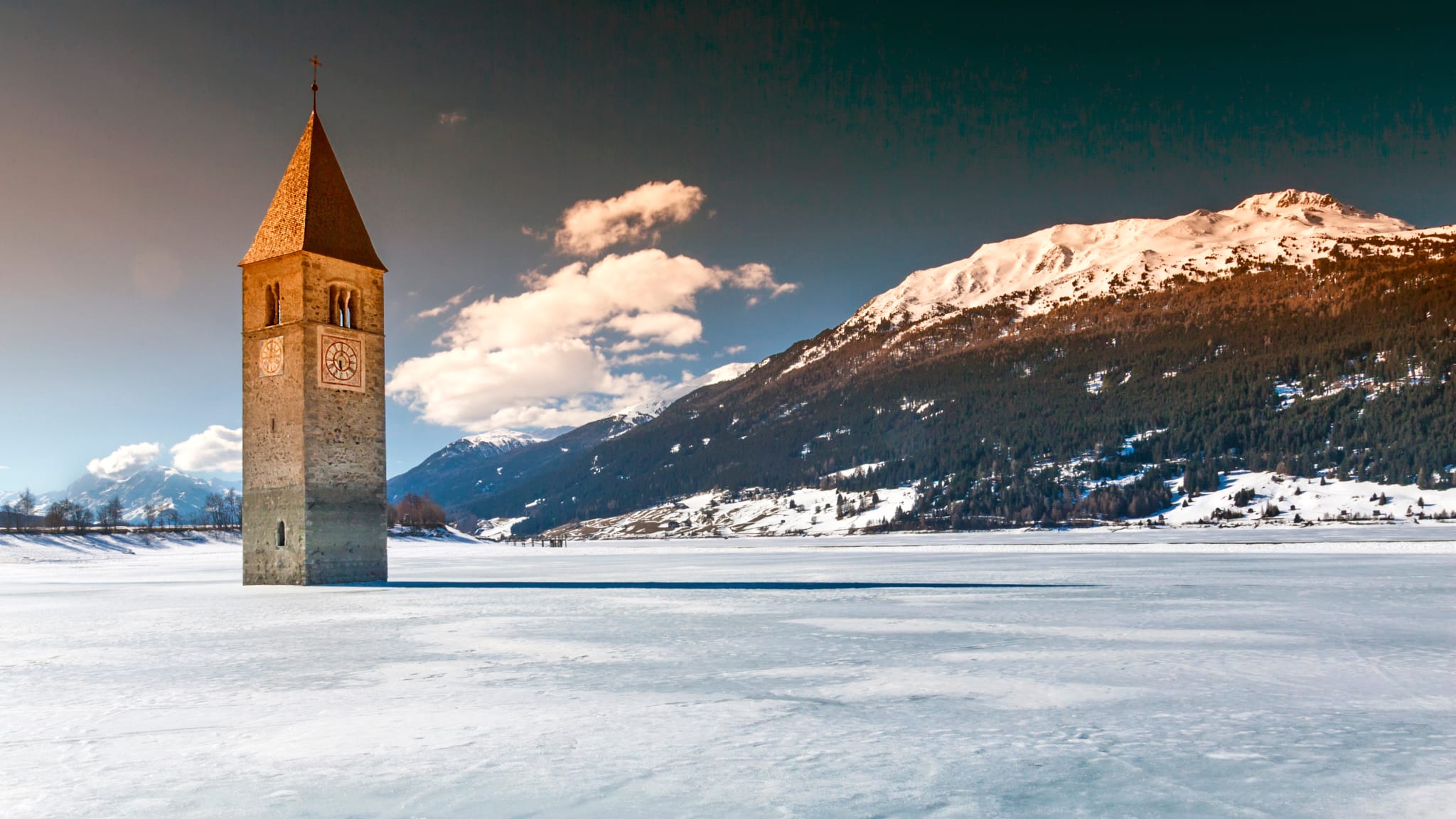 Bell Tower In Frozen Lake Reschen Against Sky