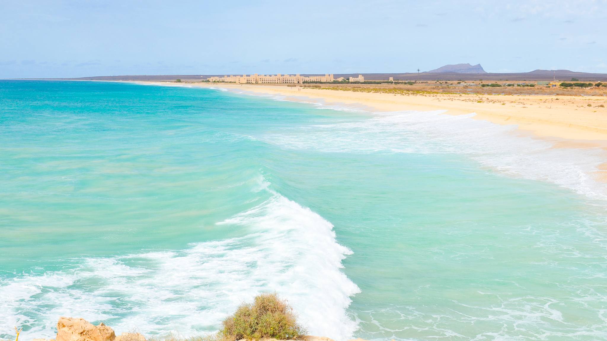 Ein weiter leerer Strand mit türkisem Wasser