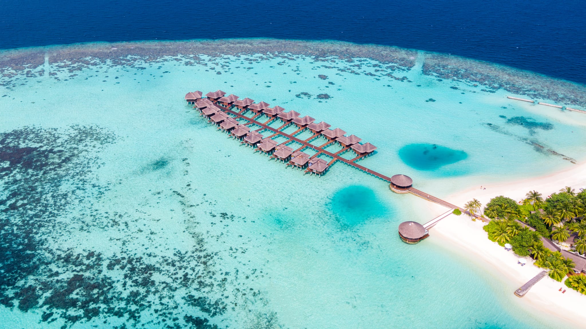 Luftbild eines Atolls mit Wasserbungalows