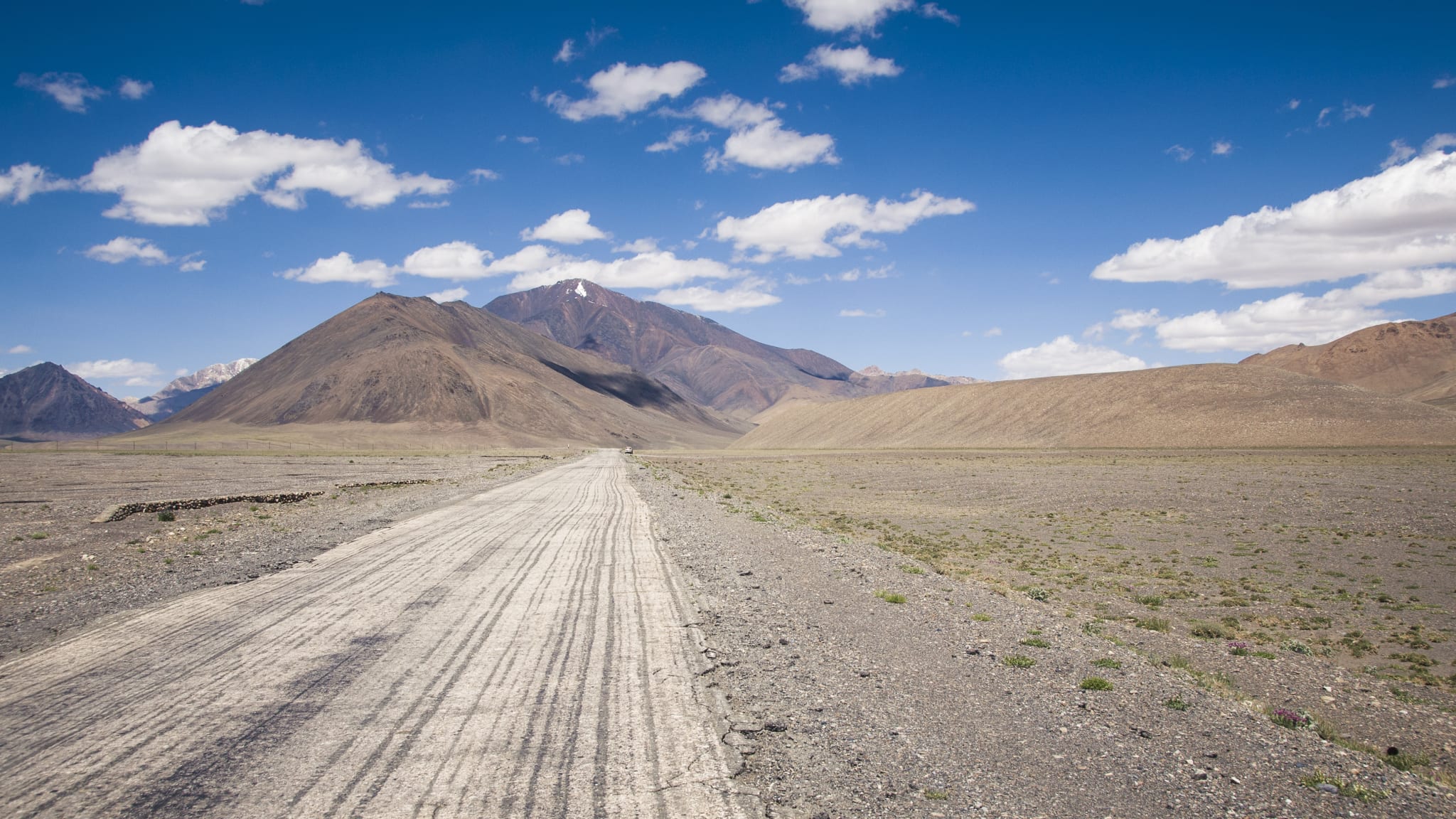 Straight road across the Pamir Plateau in Tajikistan, Central Asia