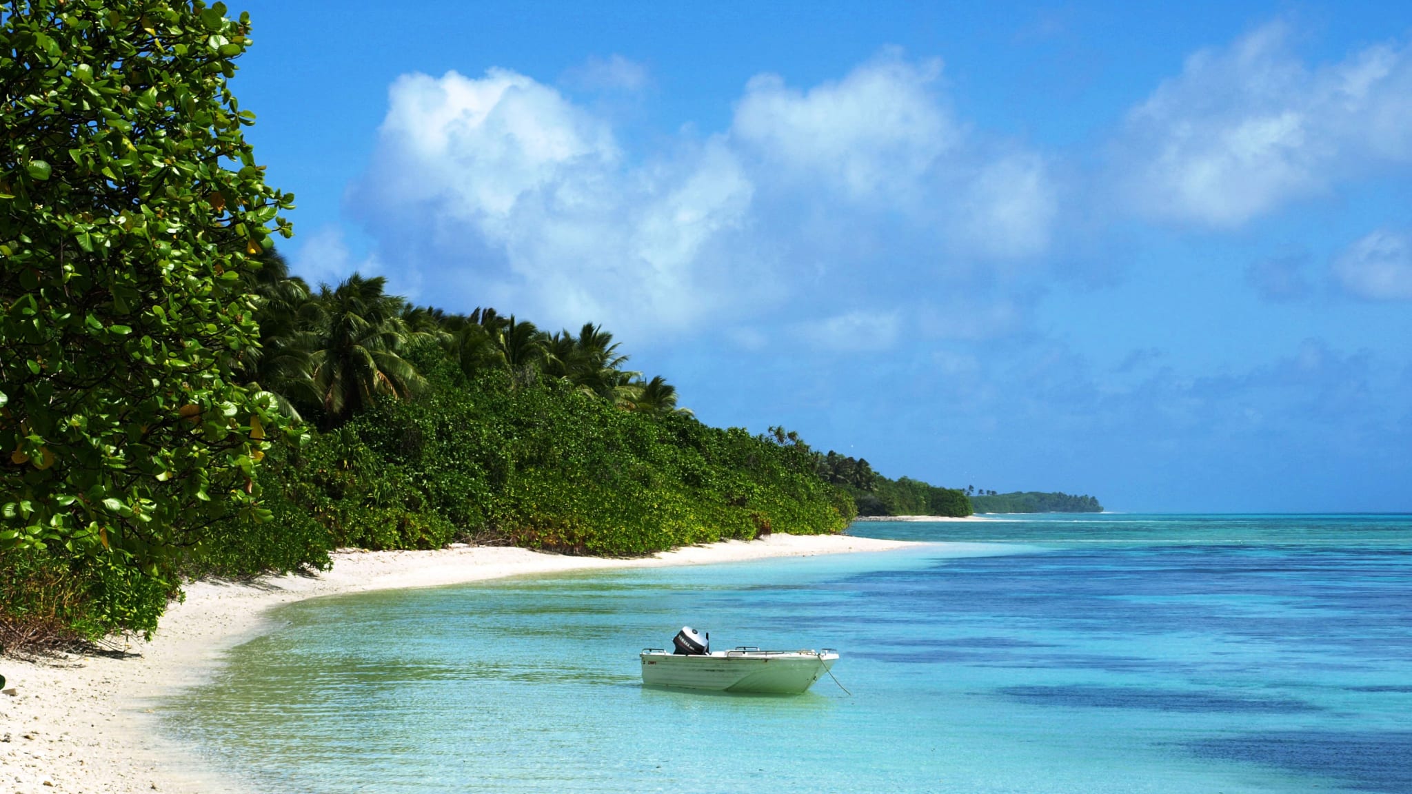 Lone boat in a lagoon next to beautiful beach