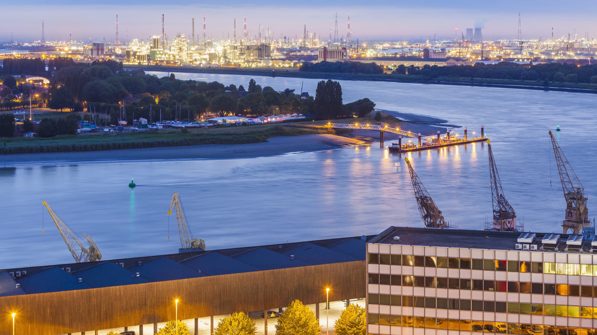 Belgium, Flanders, Antwerp, View to dock area with industrial area at Scheidt river in the evening