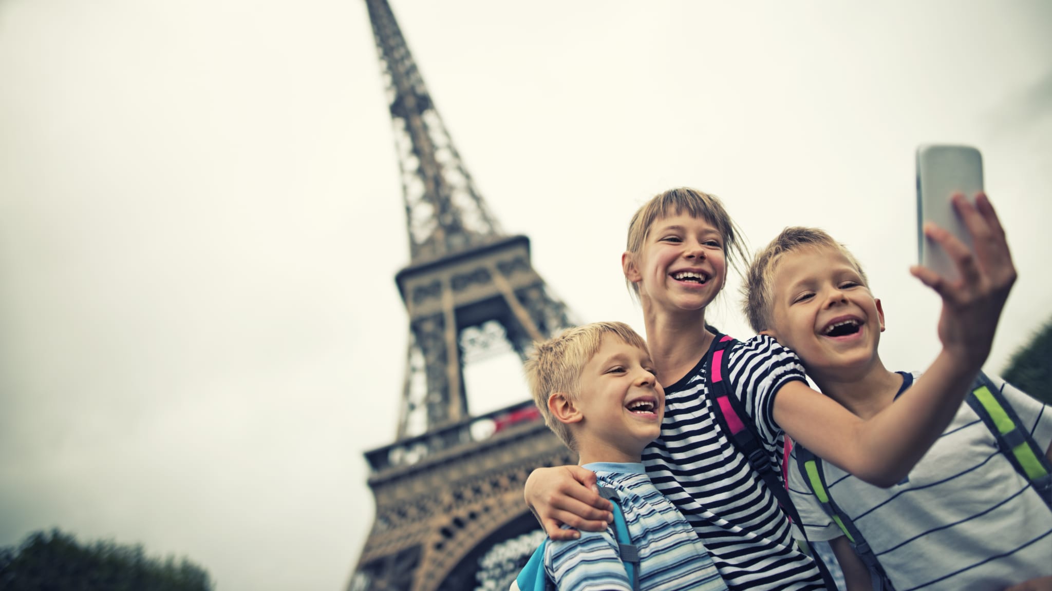 Kinder machen ein Selfie unweit des Eiffelturms in Paris, Frankreich