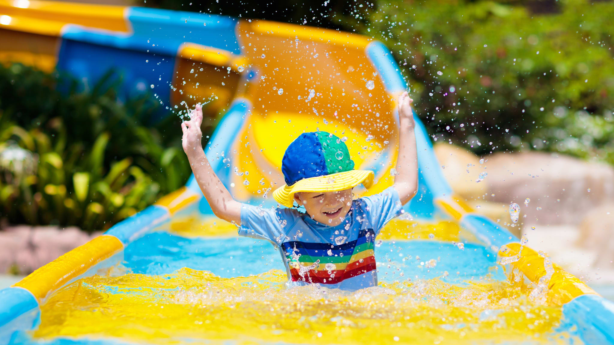 Kleinkind beim Rutschen im Wasserpark  © Getty Images - FamVeld