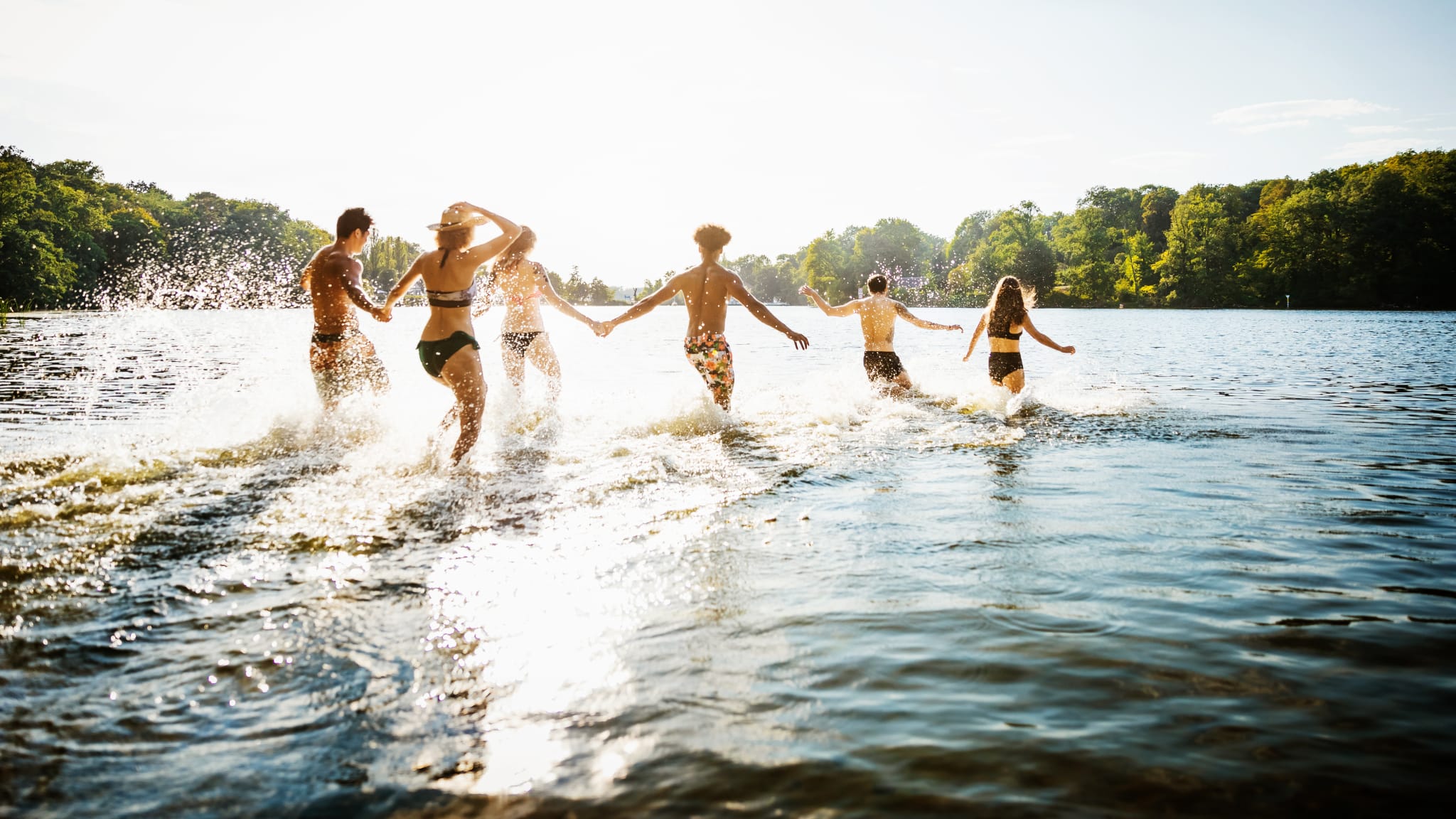 Freunde laufen in einen Badesee