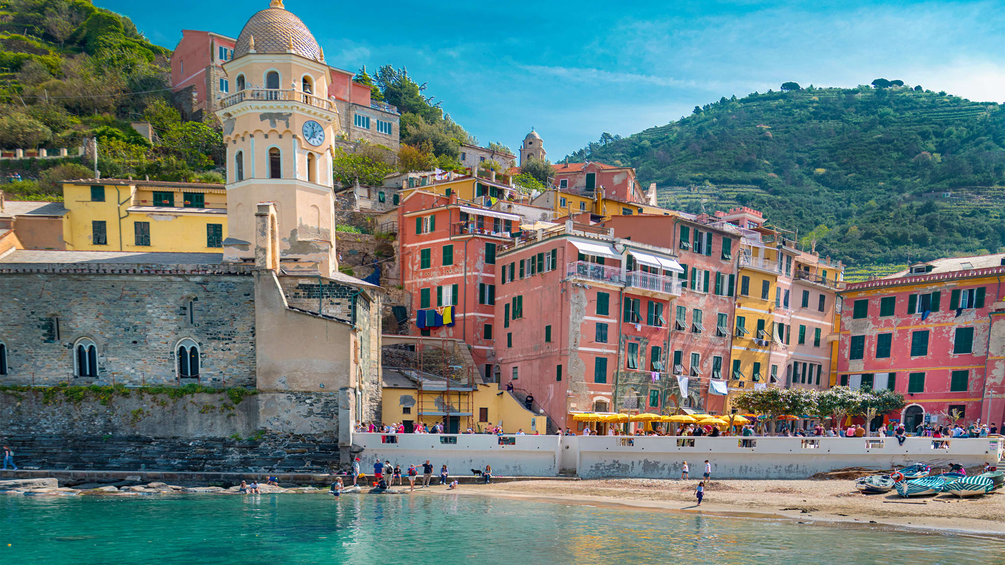 Ein Boot im blauen Wasser am Strand eines Dorfs in Cinque Terre