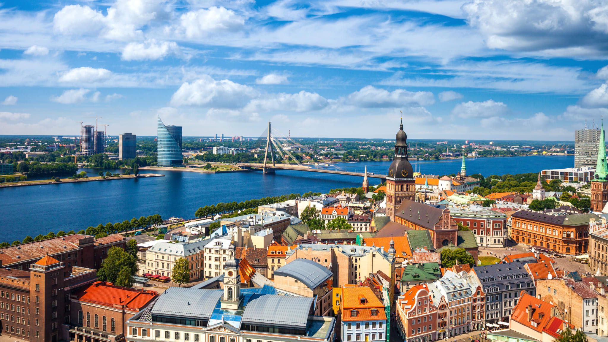 Blick auf die Altstadt von Riga. Hinter der Altstadt liegt ein Fluss und dahinter eine modernere Siedlung.