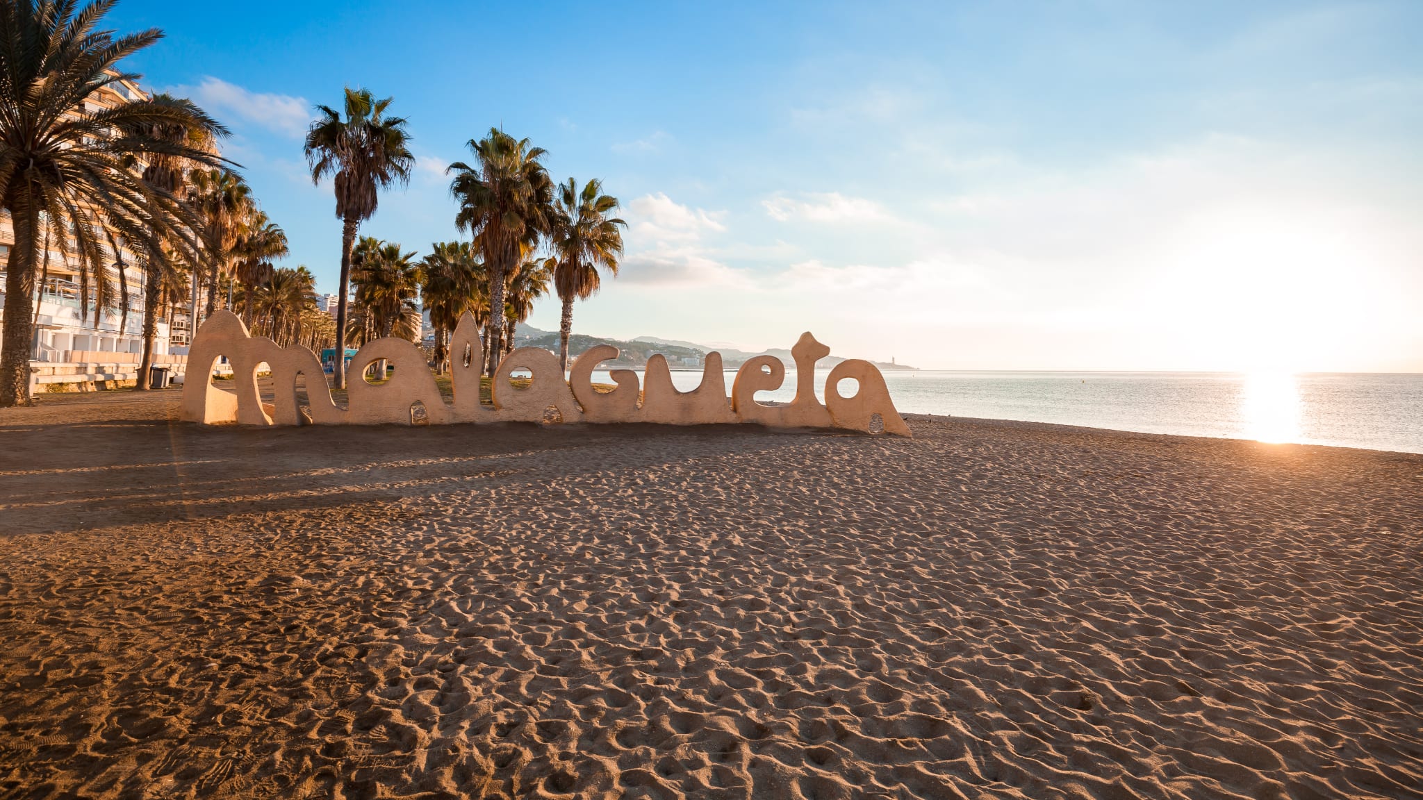 Ein Strand mit Palmen und einer Buchstaben-Statue