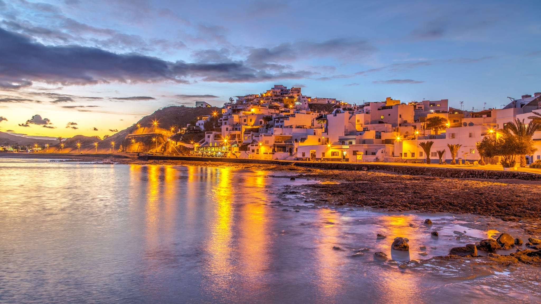 Ein Strand am Abend mit weißen Häusern im Hintergrund